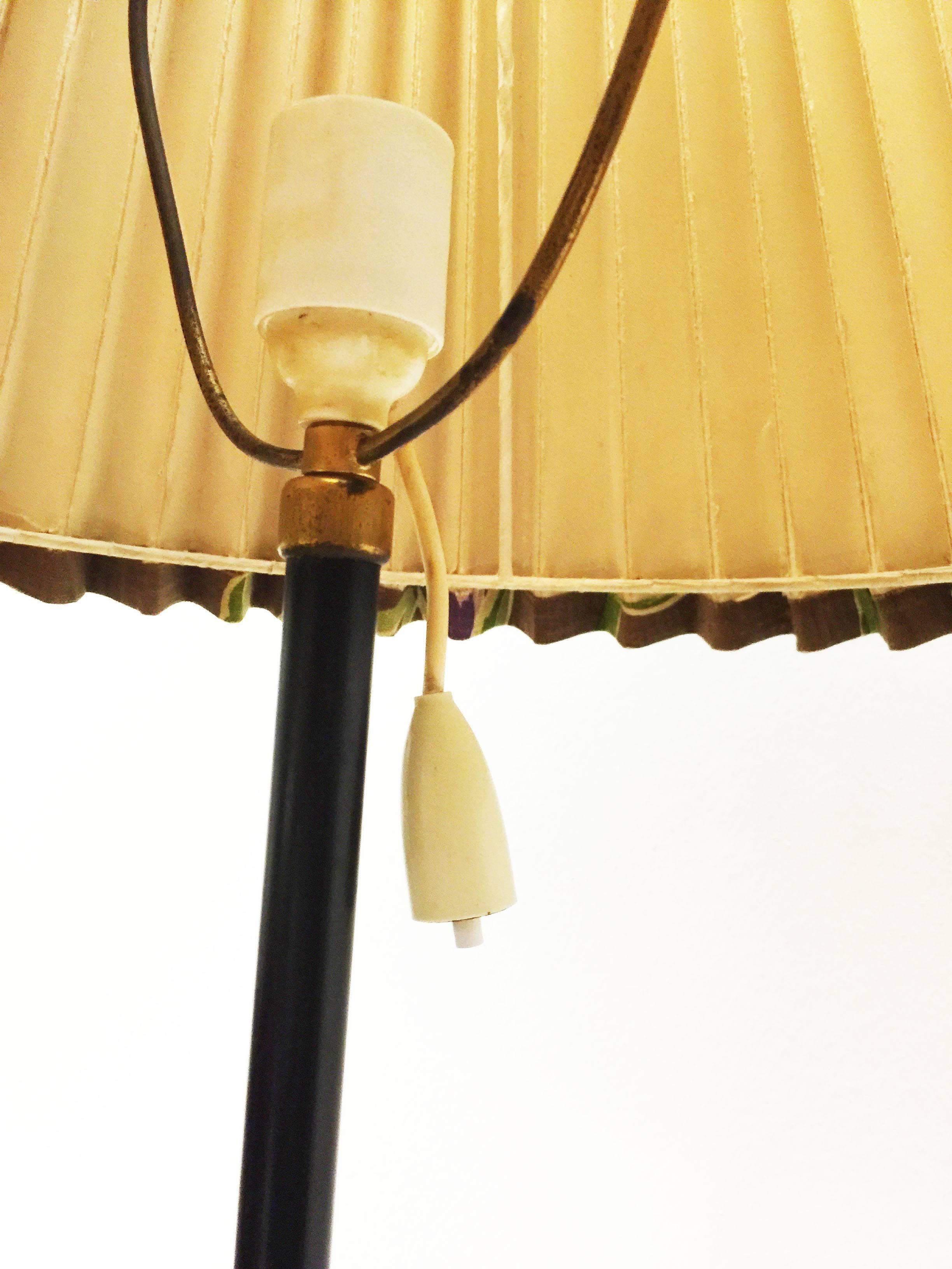 Seltener J.T. Kalmar-Lampe aus den frühen 1960er Jahren.
Fuß aus Messing, schwarz lackiertes Messingrohr, plissierter Leinenschirm mit Blumenmotiv. 
Kleine Patina am Messingfuß.
