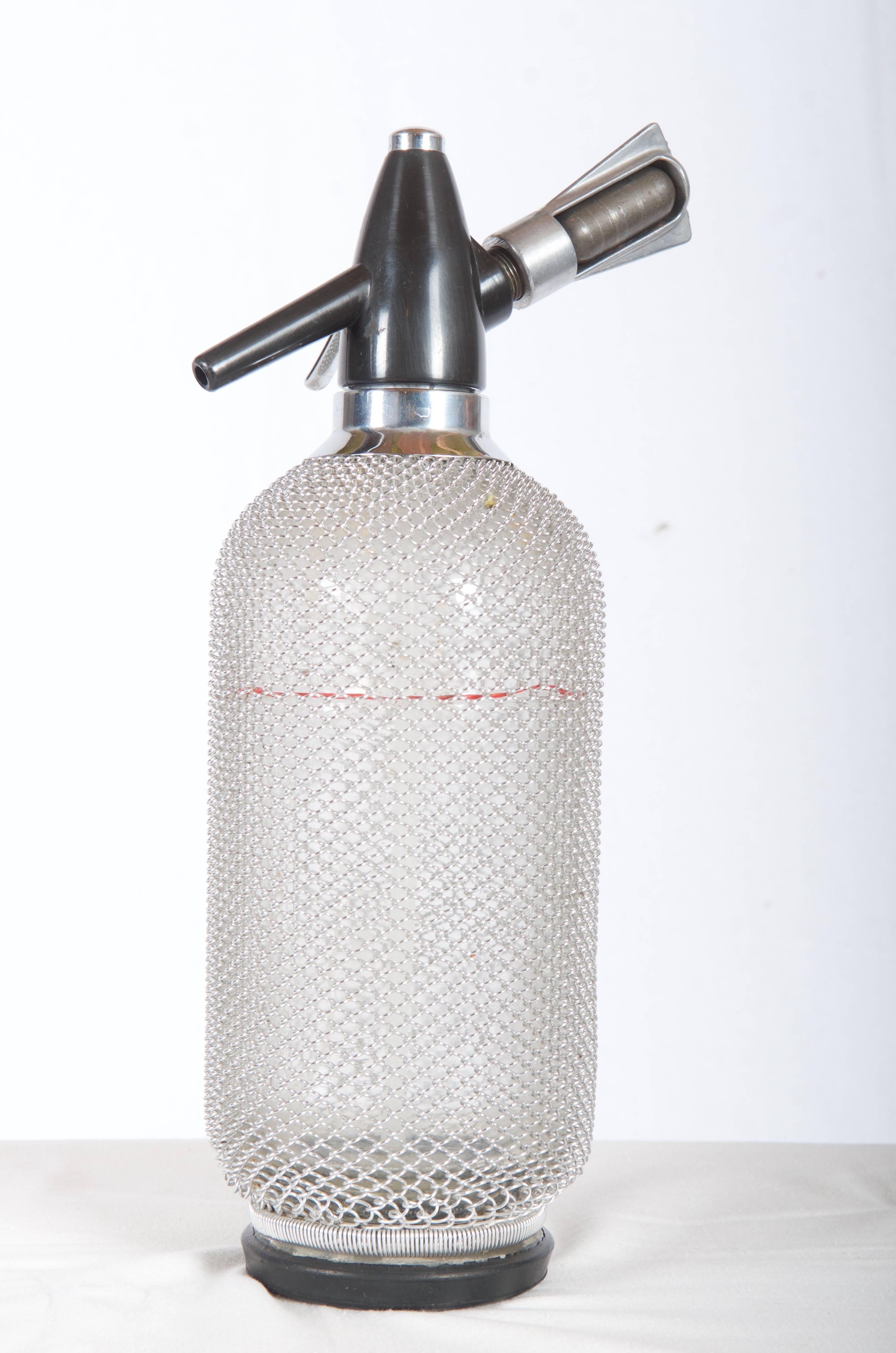 Seltene Vintage Glas Siphon Seltzer Soda Flasche  Mit Maschendraht aus dem Jahr 1970
Der Artikel befindet sich in einem einwandfreien Zustand.
Maße: 13 1/2 Zoll hoch und 4 Zoll Durchmesser auf der Basis