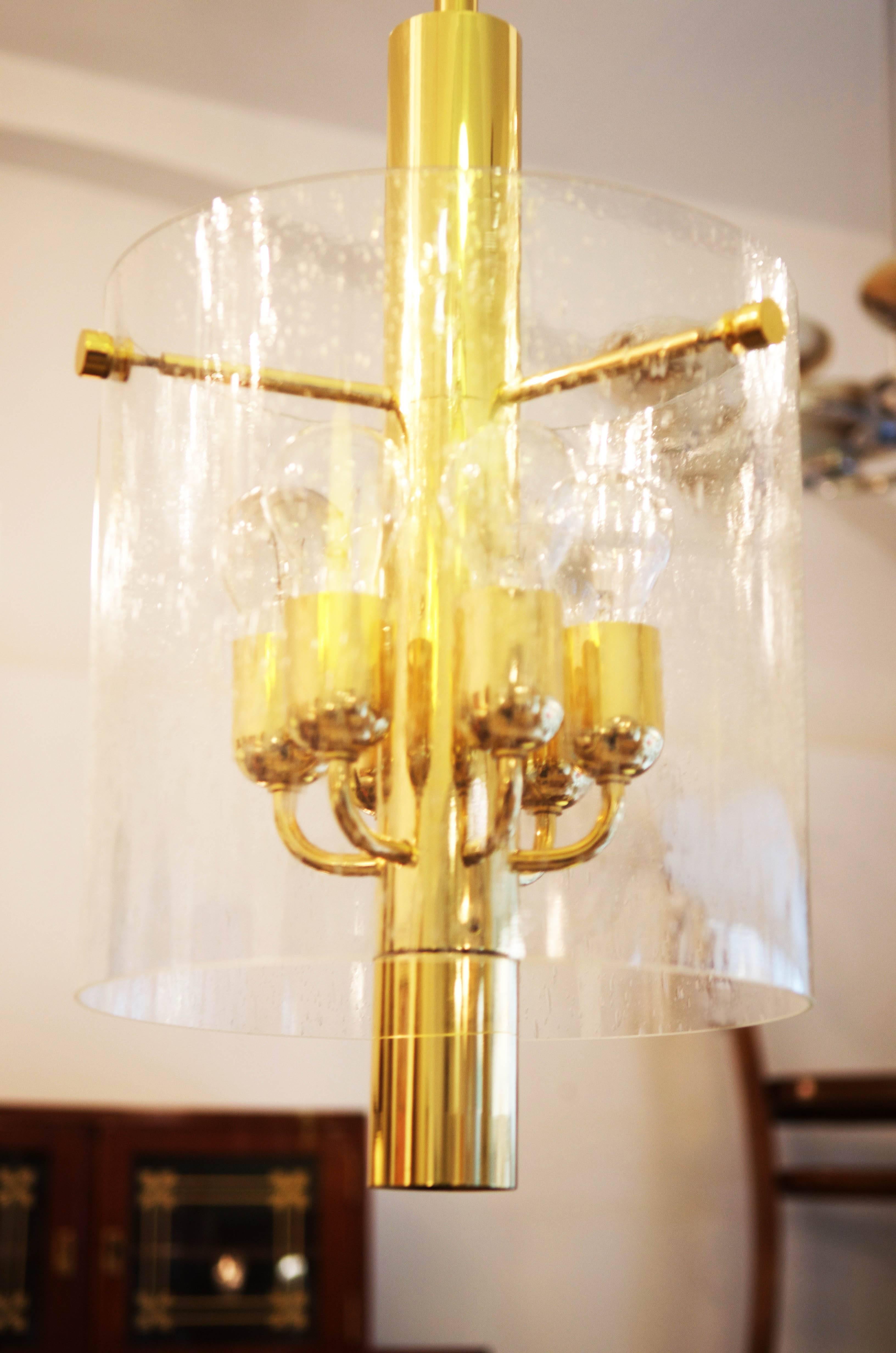 Questa lampada a sospensione Glashütte Limburg 4298 colpisce per il suo design ridotto all'essenziale. Riceve  attraverso il diffusore cilindrico in vetro cristallino soffiato a mano, attraverso il quale sono visibili le lampadine o le lampade. La