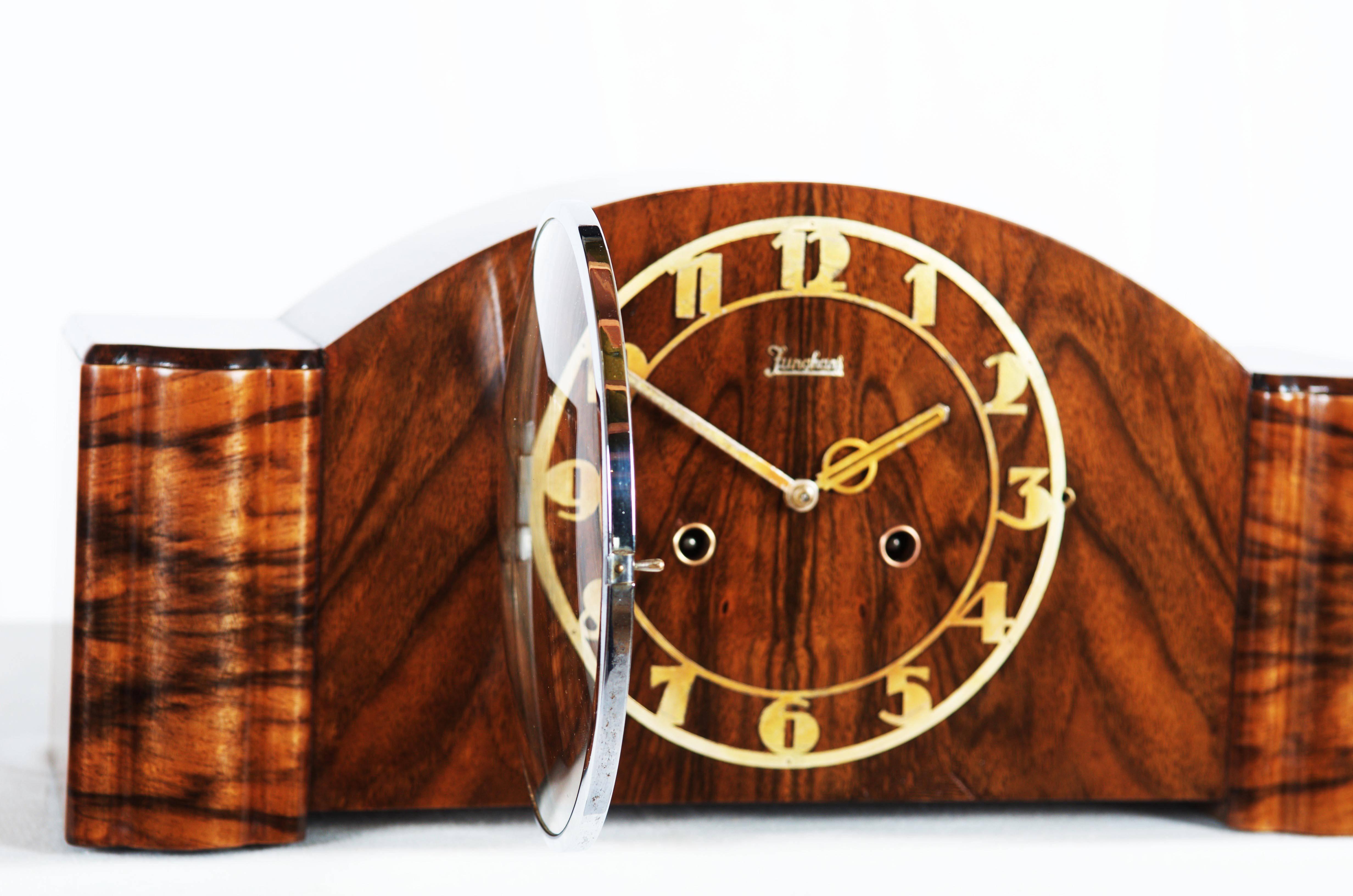This antique Junghans Art deco mantel clock was designed between the 1920s and 1940s.
It is made from softwood and covered with nut veneer. 
Wood and movement restored