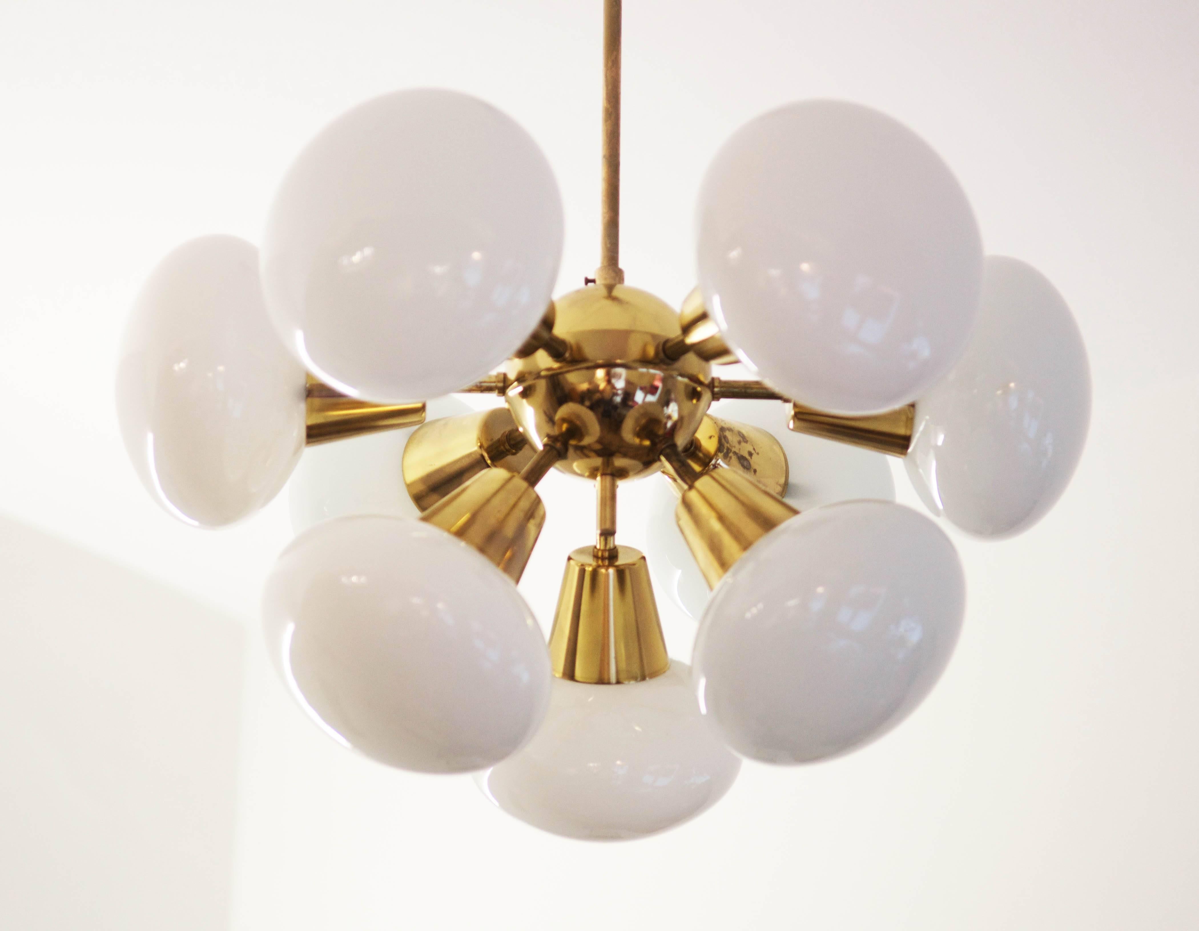 Space age chandelier made of polished brass with nine round white opaline glass shades from the 1960.