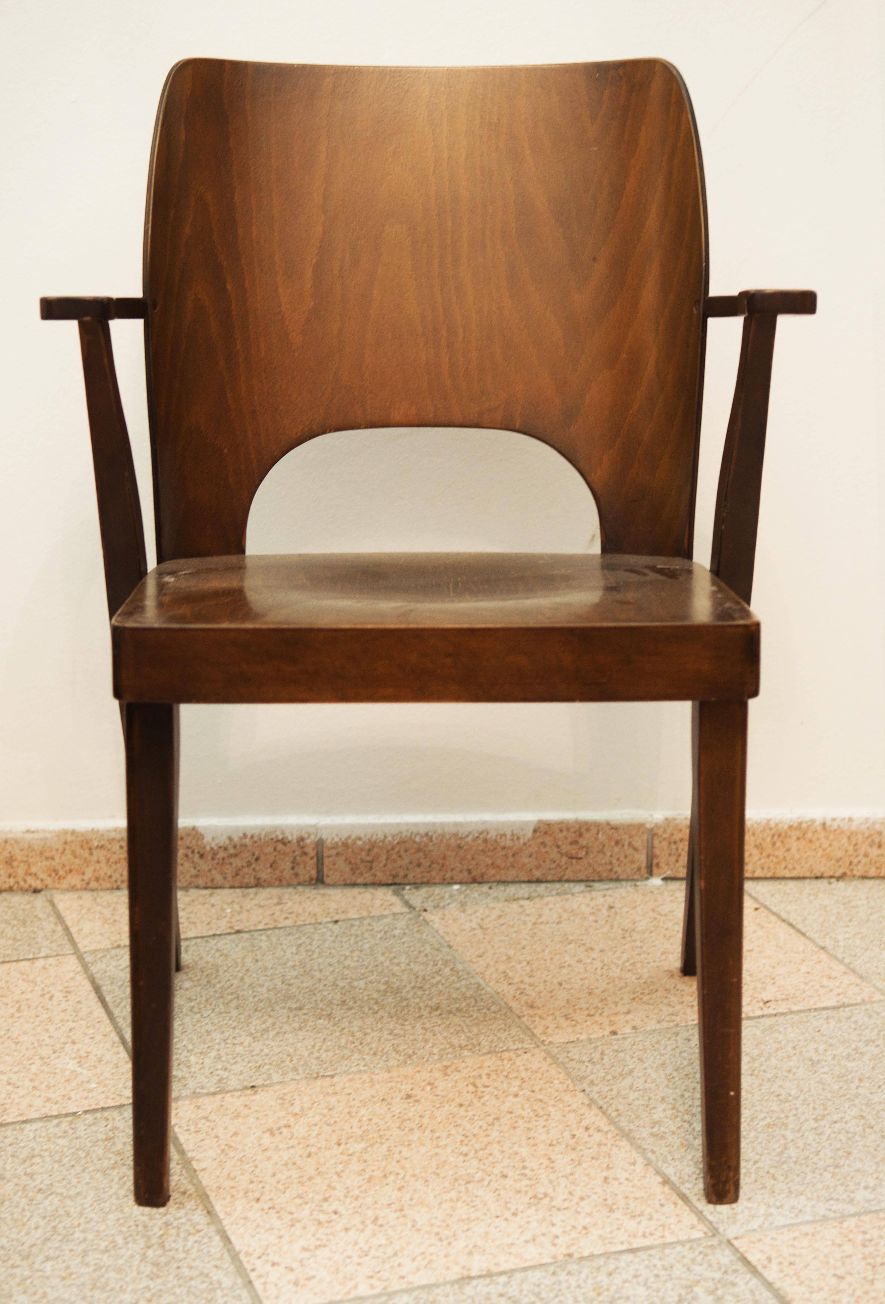 Stacking chair for apartments and lecture halls, with seat and rest made of plywood. The slit in the side frame is used to push through a bar to form a seated row at lectures. 
Made by 