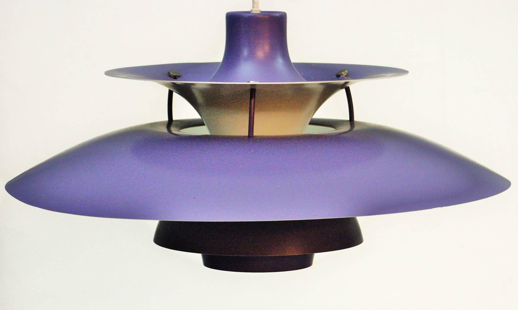 The Lamp was designed by Poul Henningsen for Louis Poulsen in the 1958.
Designed to hang low over the table, they create a 100% glare-free light
these pendants have purple band details on the underside and orange bands 
on the upper tier, which