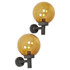 A Pair Of Outdoor Metal Wall Lamps With Glass Shades