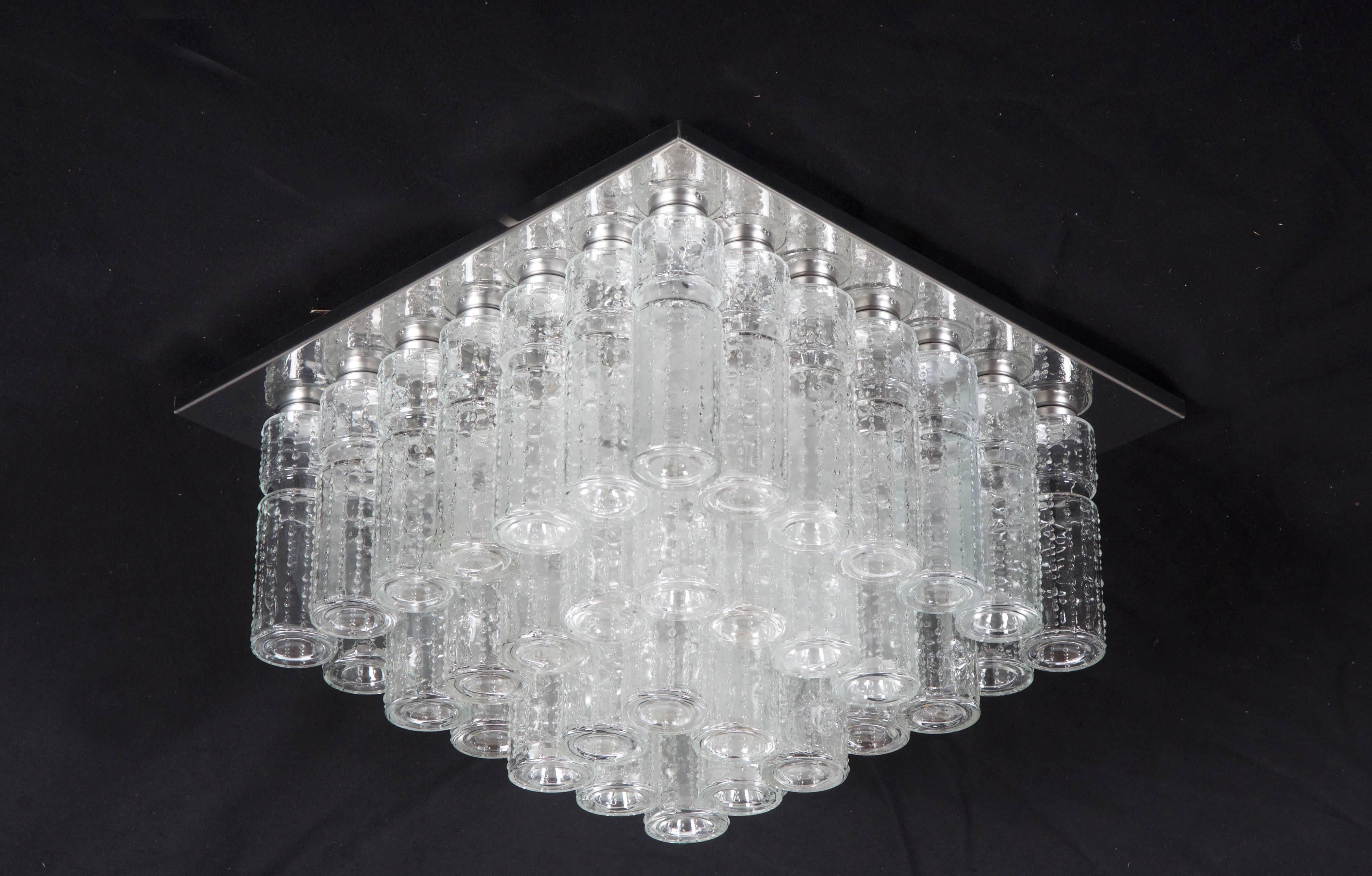 Amazing flush mount chandelier with 48 hanging hand blow textured hollow glass prisms mounted on a chromed steel frame. Made by Glashütte Limbung in Germany model number 2436 and designed by Boris Tabacoff in the 1970s.
Excellent original