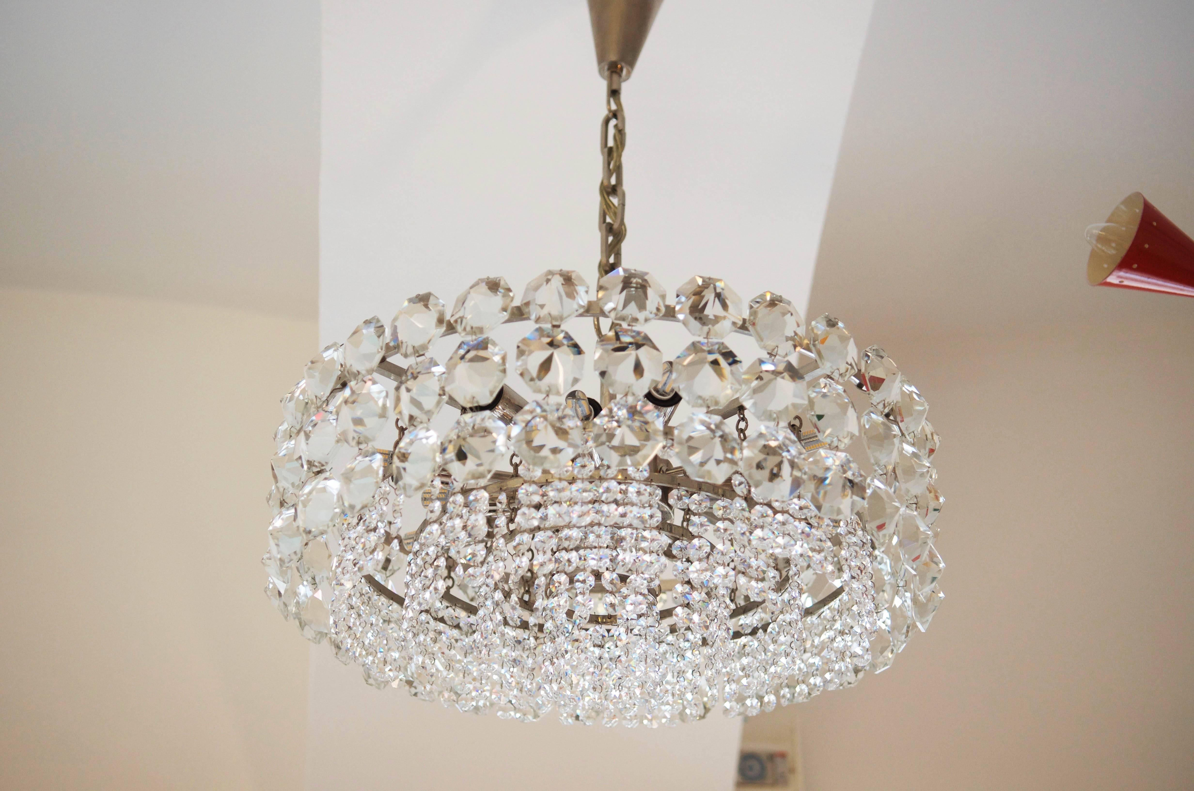 Impressive and stunning crystal chandelier from circa 1960s by Bakalowits & Sohne. Brass construction nickel-plated, with five ring with hand-cut crystals.
Electric with 12 lights E14 sources with two circuits.
Dimensions: Diameter 52cm.
Total