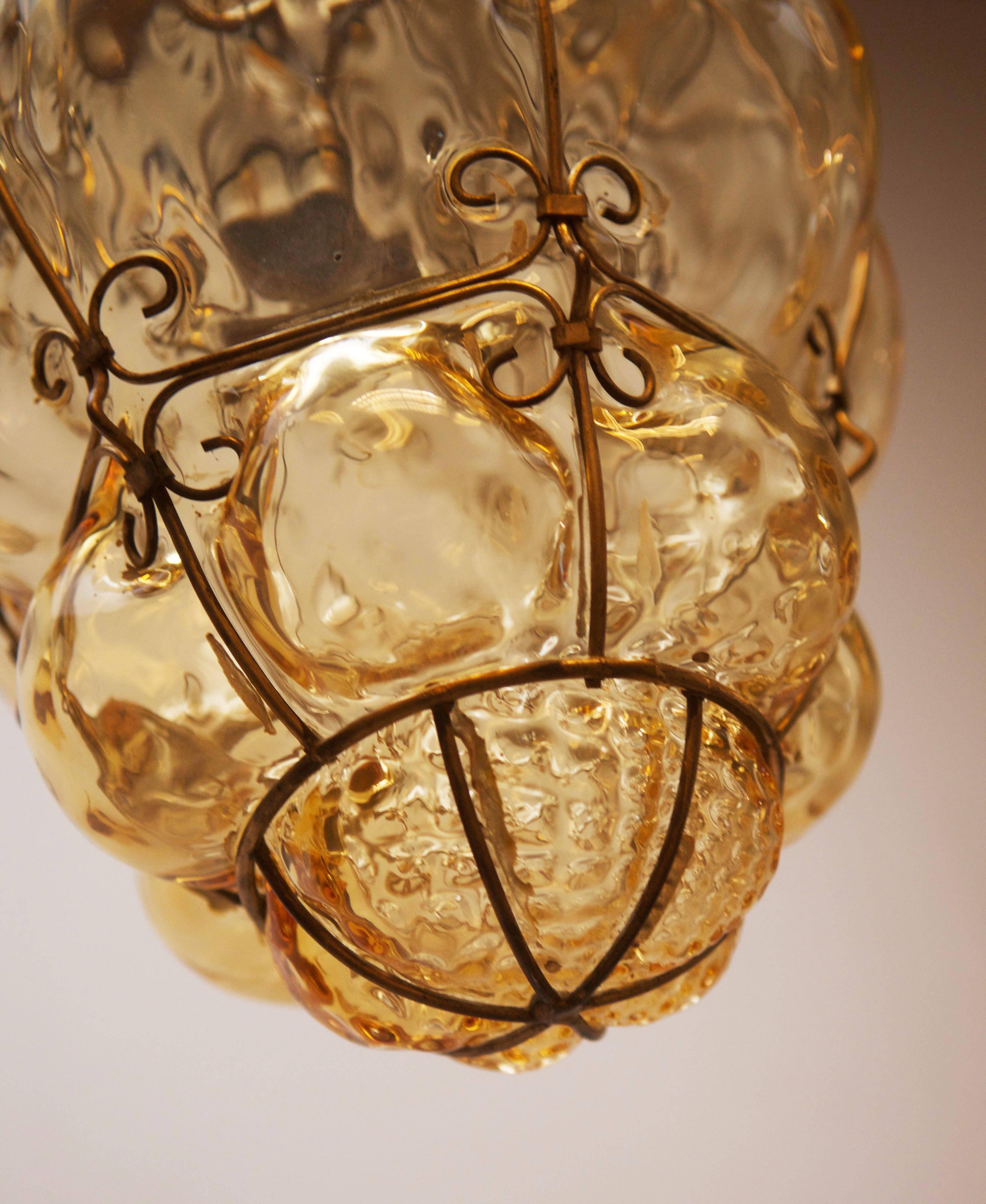 Beautiful Italian Murano glass bubble pendant manufactured by Seguso in the 1960s. It is made from handblown amber coloured glass with a bronze coloured steel cage.
Measurements: height 13.1/2