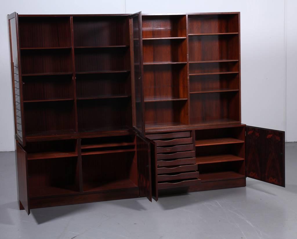 Four piece hardwood cabinet bookcase designed in the late 1960s by Gunni Omann and produced by Omann Jun Mobelfabrik. Shelf system consisting of two parts and an upper part fined with hardwood, a cupboard fined with mahogany. Front with shelves and