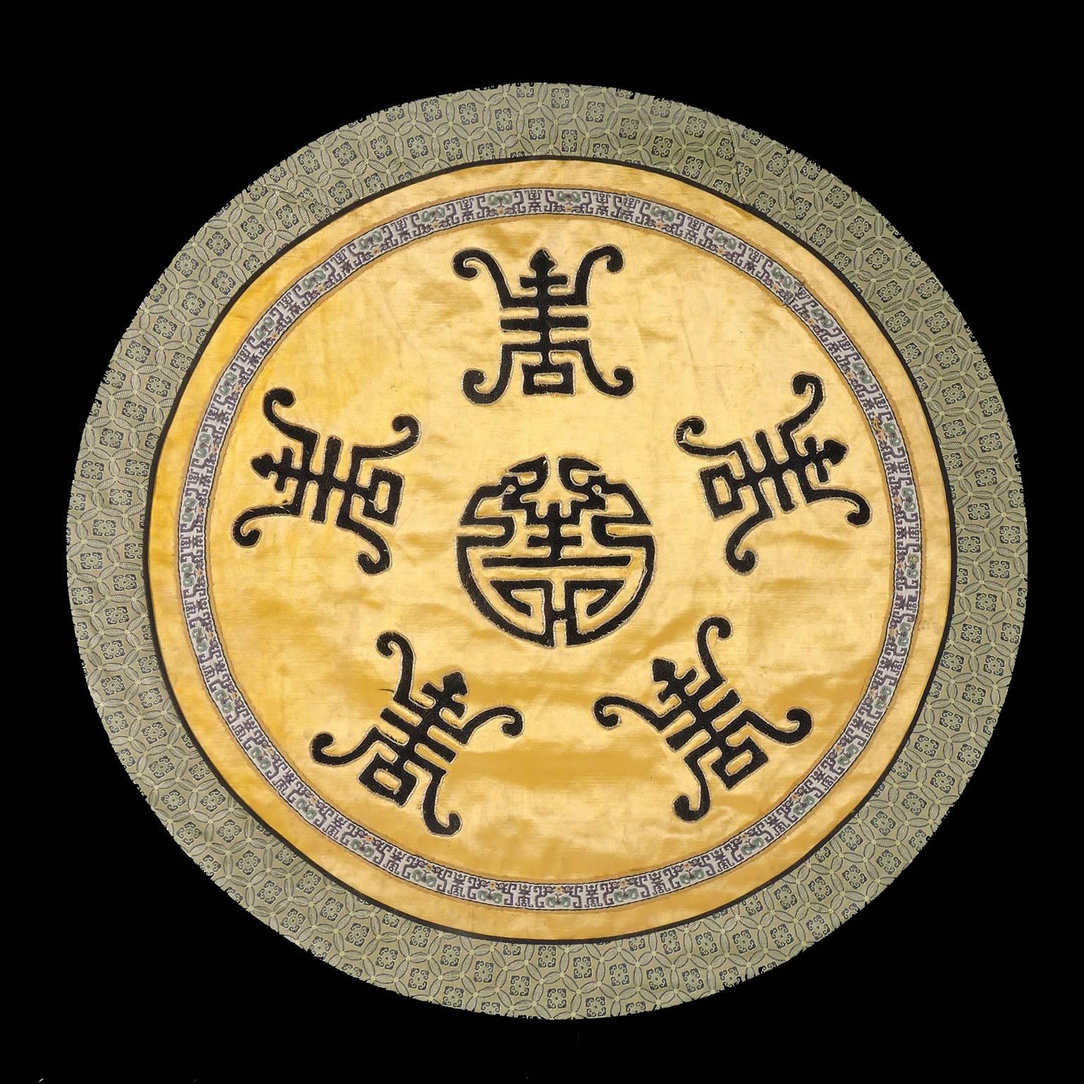 19th century Chinese embroidered silk roundel textile, of gold silk ground with dark blue embroidered central medallion Shou symbol of longevity surrounded by five calligraphic representations of the Shou symbol. Diameter of textile: 19 inches;