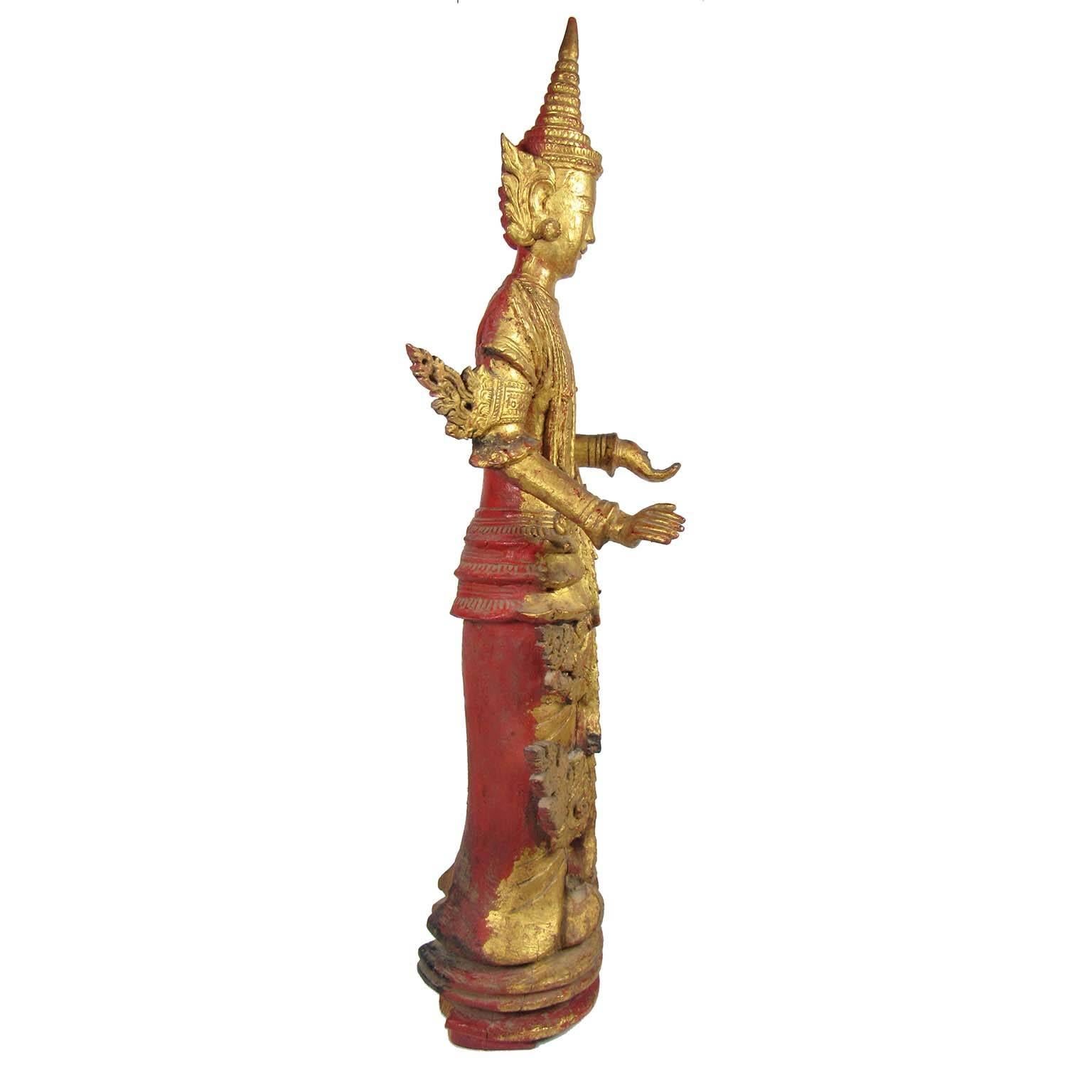 A gilt wooden figure of a standing Buddha, late 19th century, Thailand.
Measures: Height 35 in. (88.9 cm), width 12 in. (30.48 cm), depth 8 1/2 in. (21.59 cm).