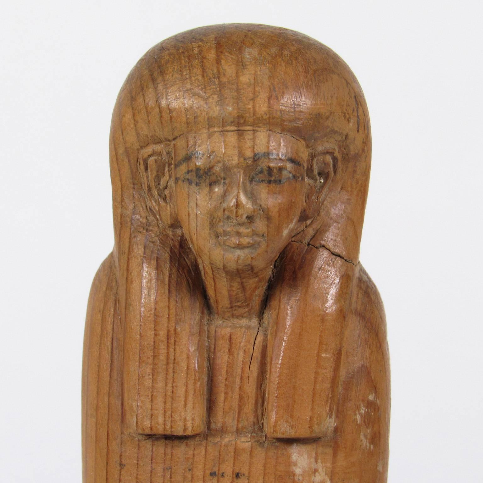 Ancient Egyptian carved wood Ushabti figure, with painted eyes mounted on a black acrylic base
measure: Height 8 inches, overall 9 x 2 7/8 x 2 inches. Purchased from Royal-Athena Galleries in NYC. Original receipt available to buyer.