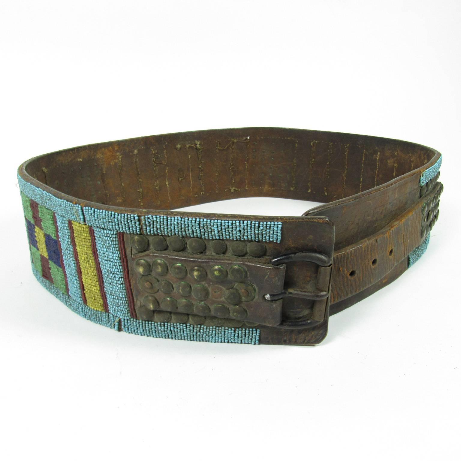 Fine mid-19th century native American colorful beaded and studded leather belt from the crow tribe. Featuring a ground of turquoise beads with yellow, green, pink, red and blue beads in a geometric design and brass studs. 
Measures: Length: 46 1/2