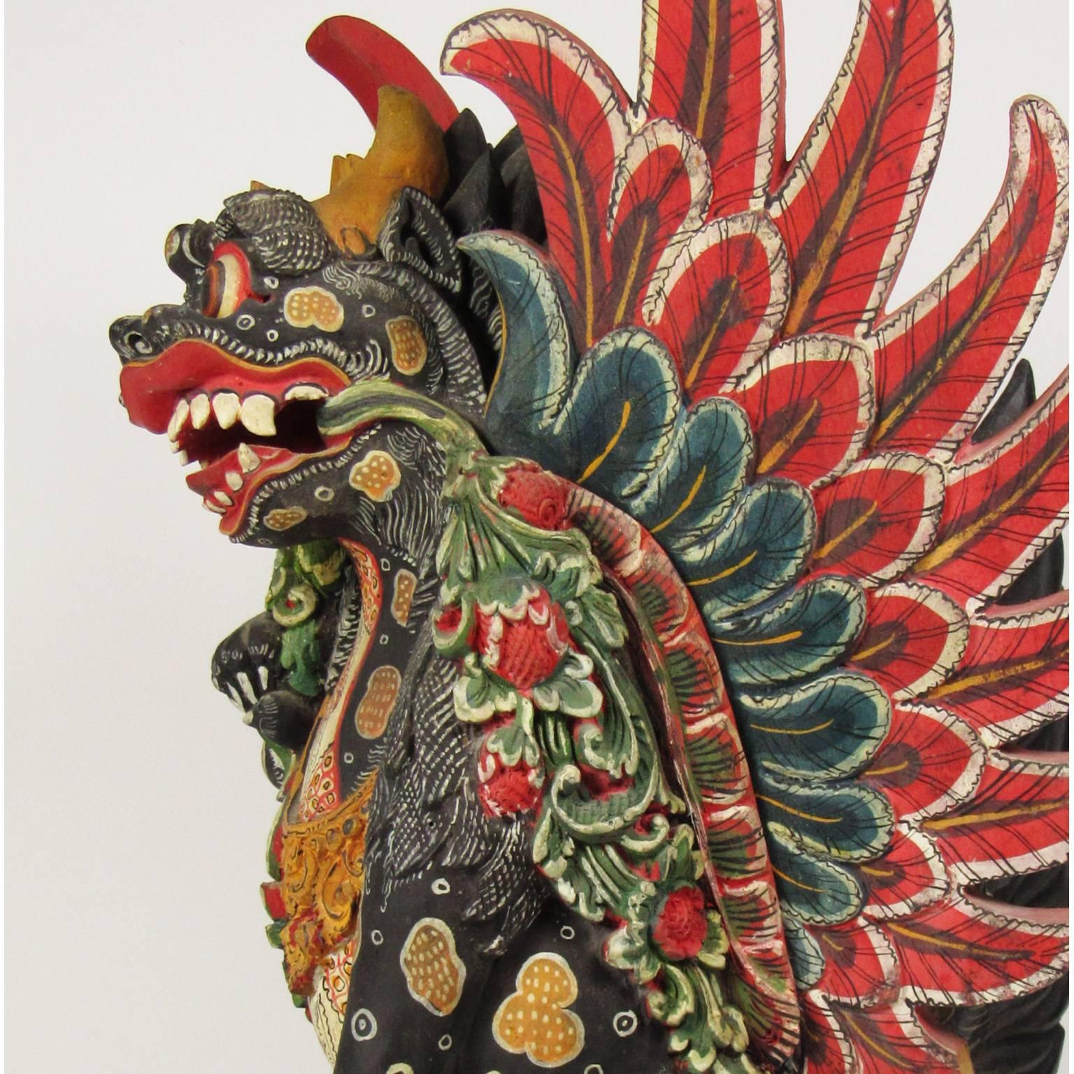 Antique early 20th century Balinese carved and polychromed wood figure of a winged lion, also known as a Singa. Singa's often serve as guardians of temples in Southeast Asia. Dimensions: 20 x 10 x 12 inches.