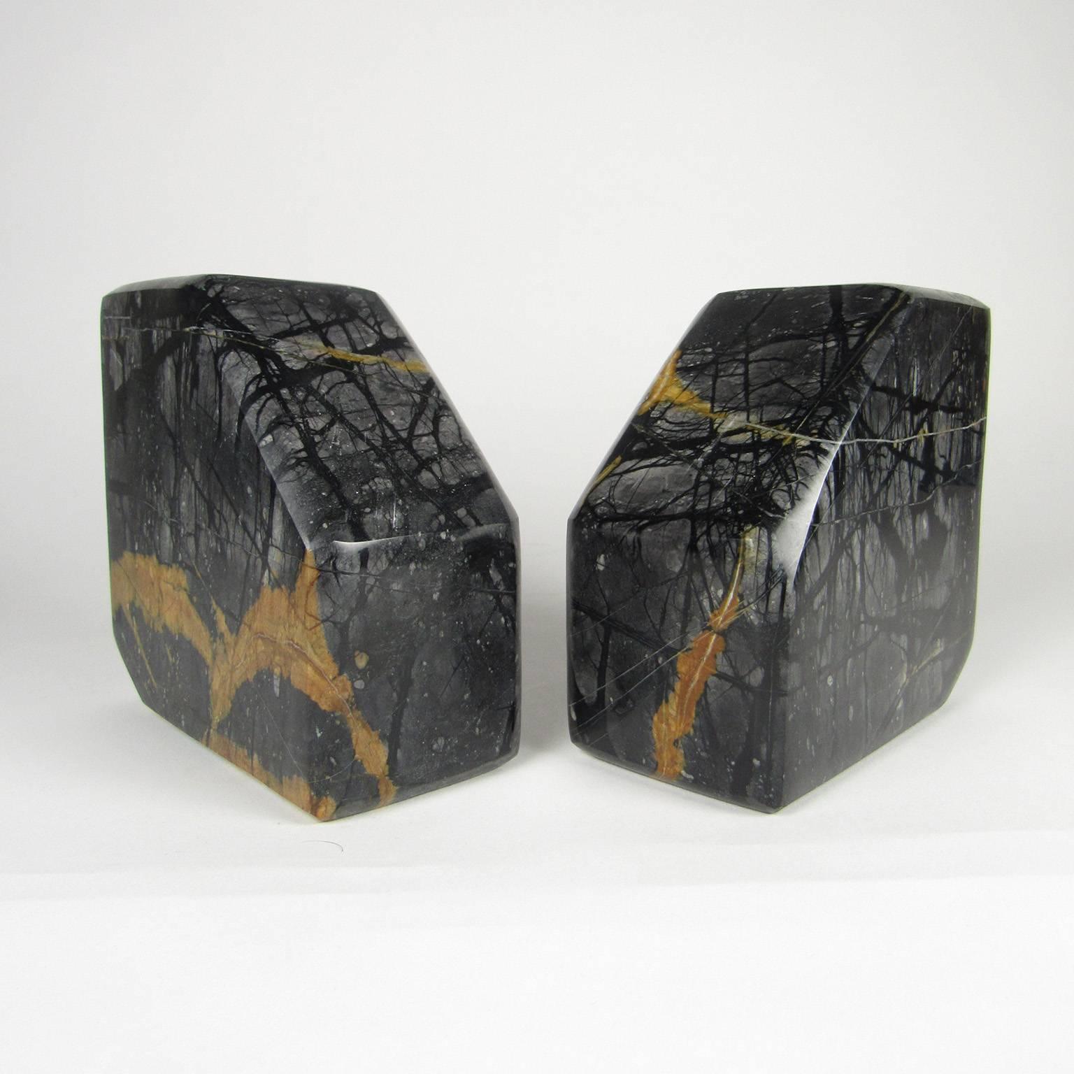 Pair of variegated black marble bookends. 
Measures: 5 1/2 x 5 1/2 x 2 3/4 inches.