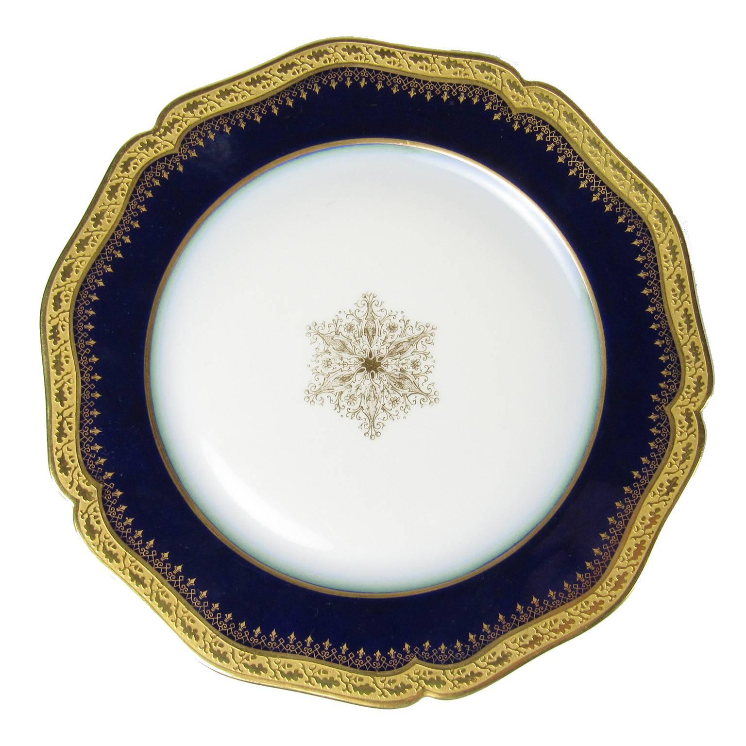 Set of eight William Guerin & Co. Limoges porcelain luncheon plates with a 24-carat gold snowflake adorning the centre, cobalt blue border and gold rims. Marked 