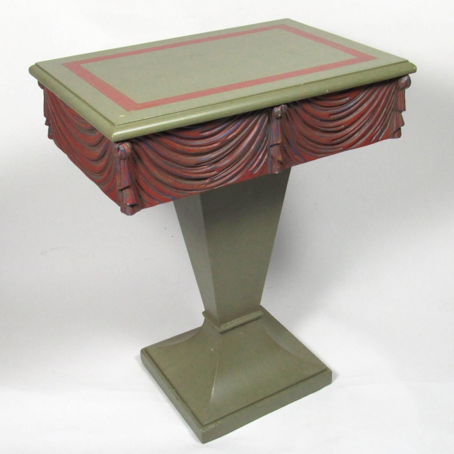 Fun pair of mid-20th century neoclassical style paint-decorated swag-carved side tables, green paint with red painted single drawers raised on a graduated pedestal base. Measures: Height 27 in., width 21 in., depth 14 1/2 in.