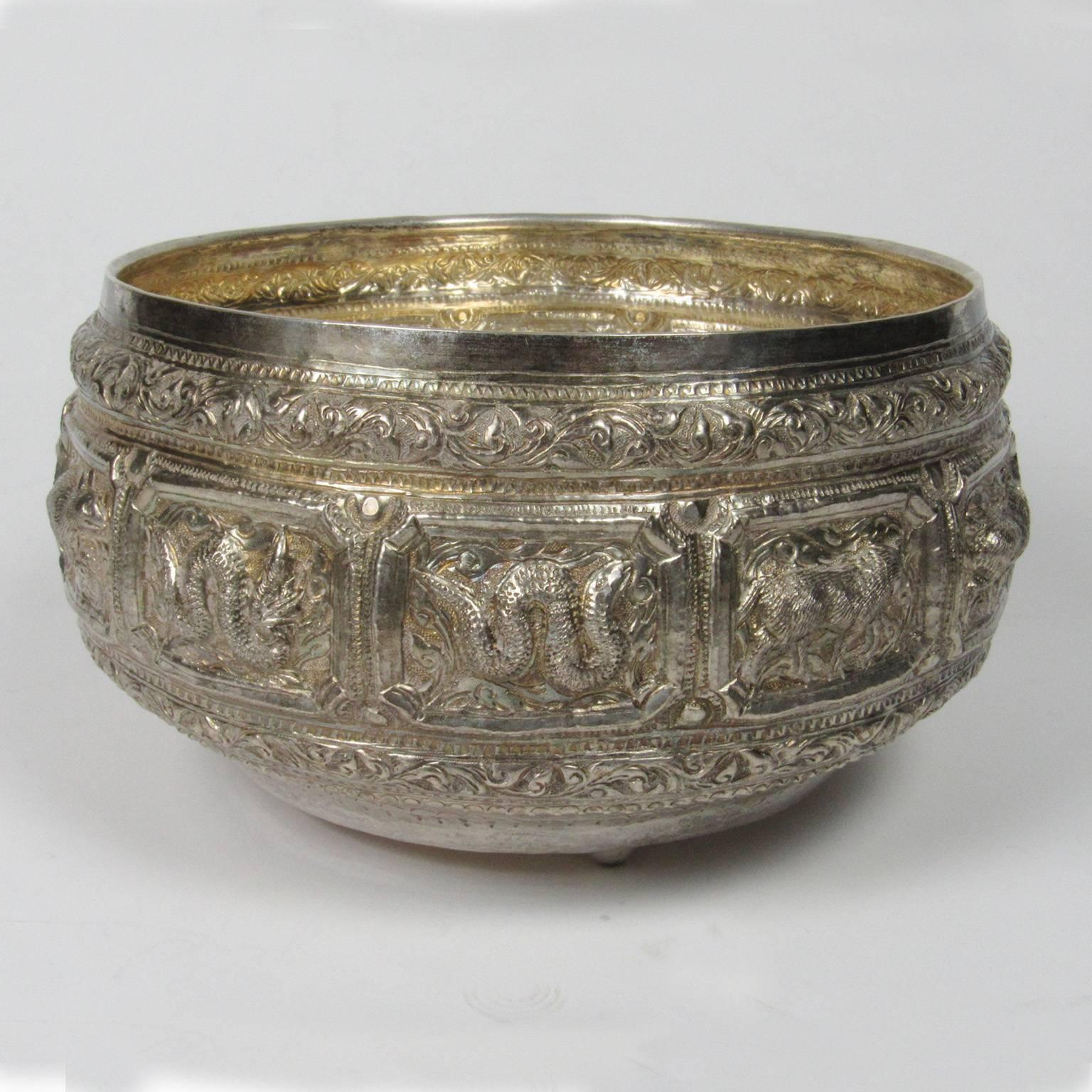 Large Burmese hand-hammered silver alms bowl with repoussé Zodiac decoration, signed on bottom. Measures: Diameter 9 in., height 5 in.