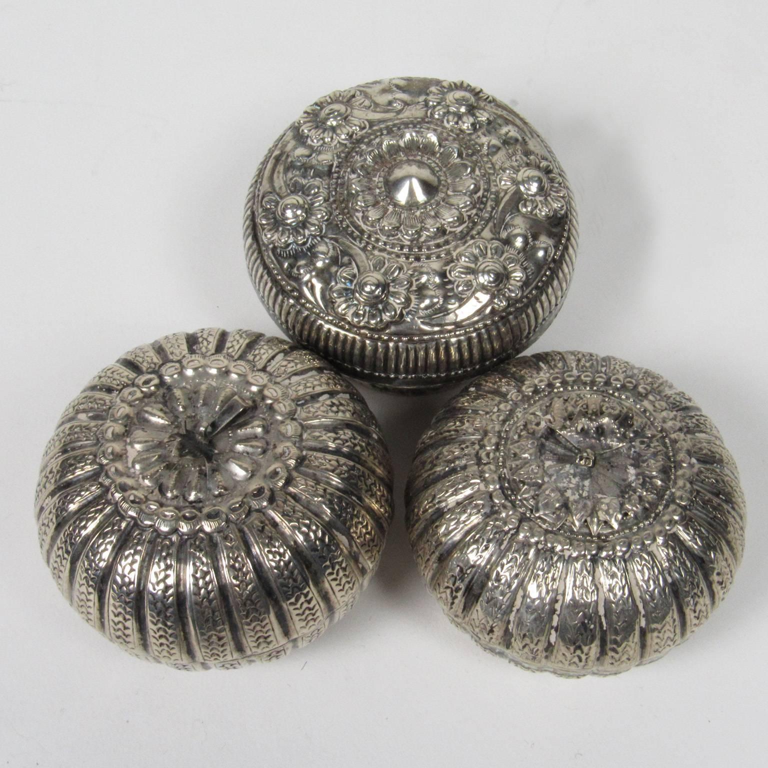 Three Burmese silver betal nut boxes. Two gourd form with gadrooned sides, the other repousse floral decoration. Inscribed on bottom. Measures: Diameter: 2 1/2 in., height: 2 in. (each).