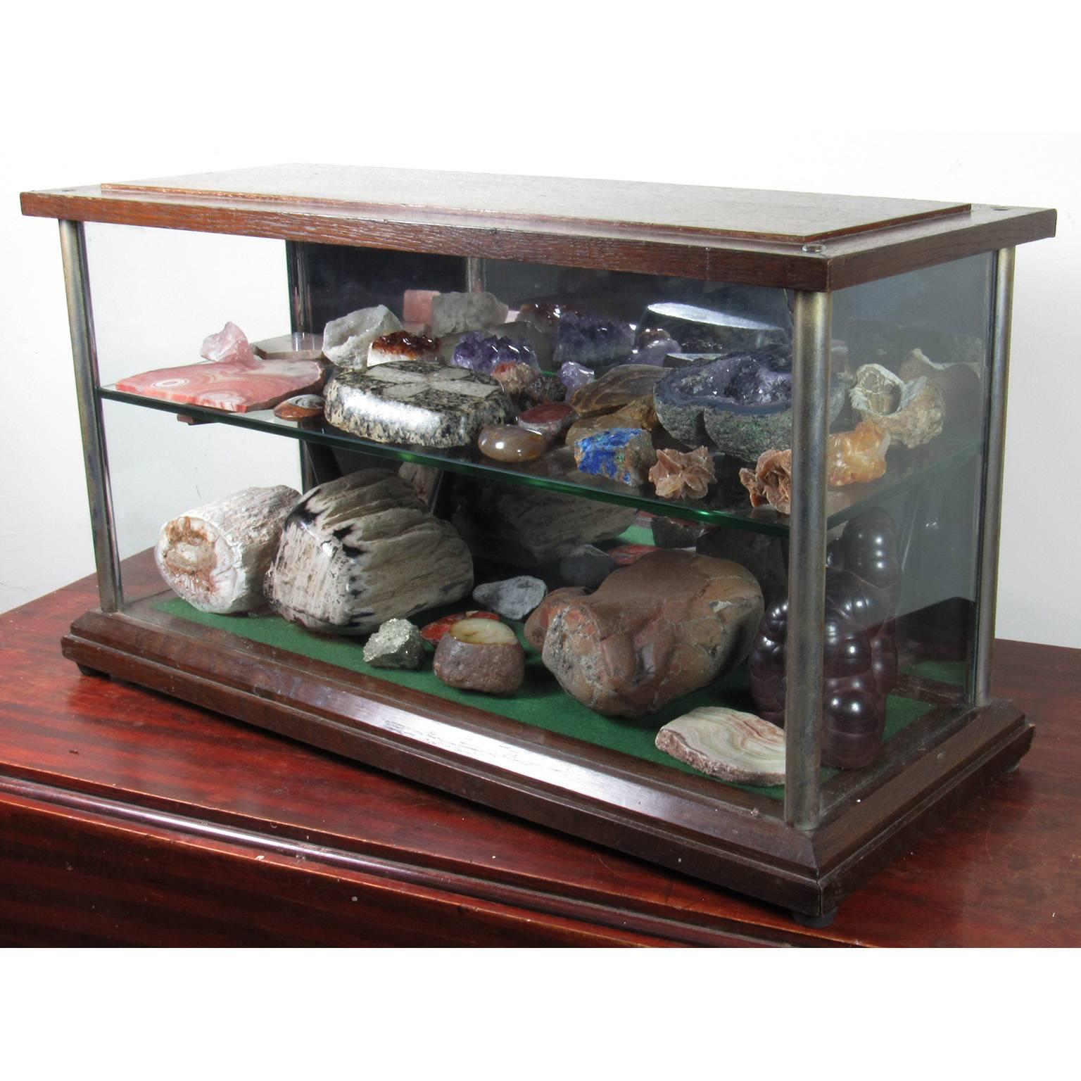 Specimen collection with 19th century mahogany and glass vitrine, comprised of approximately 37 specimens including crystal, rocks, fossils, and cross sectioned geodes. Measure: Vitrine 14 1/4 x 26 1/4 x 10 inches.