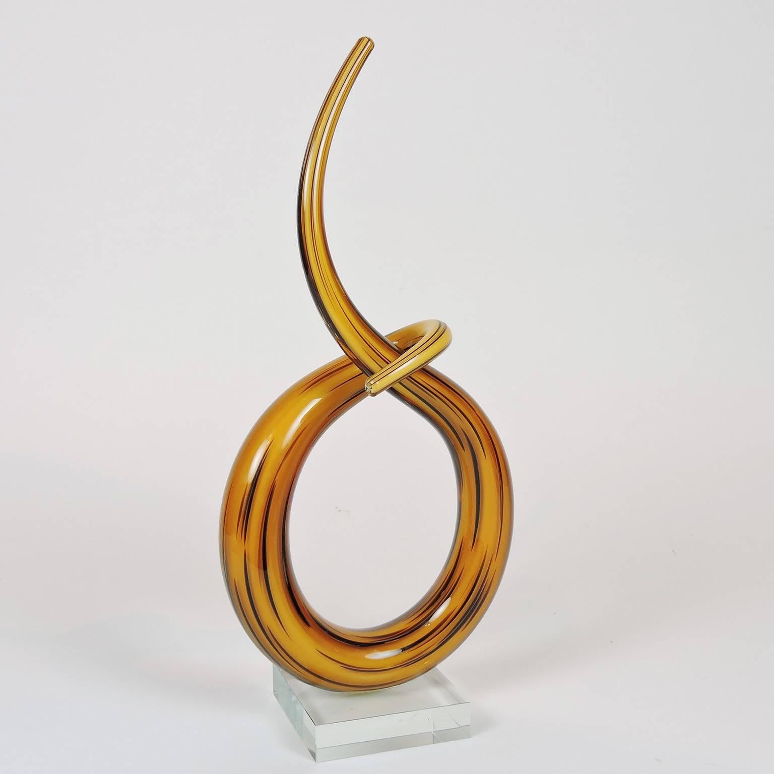 Murano handblown glass twisted knot sculpture, golden yellow and brown glass intertwined, mounted on a clear base. 
Dimensions: 13 x 6 x 3 in.