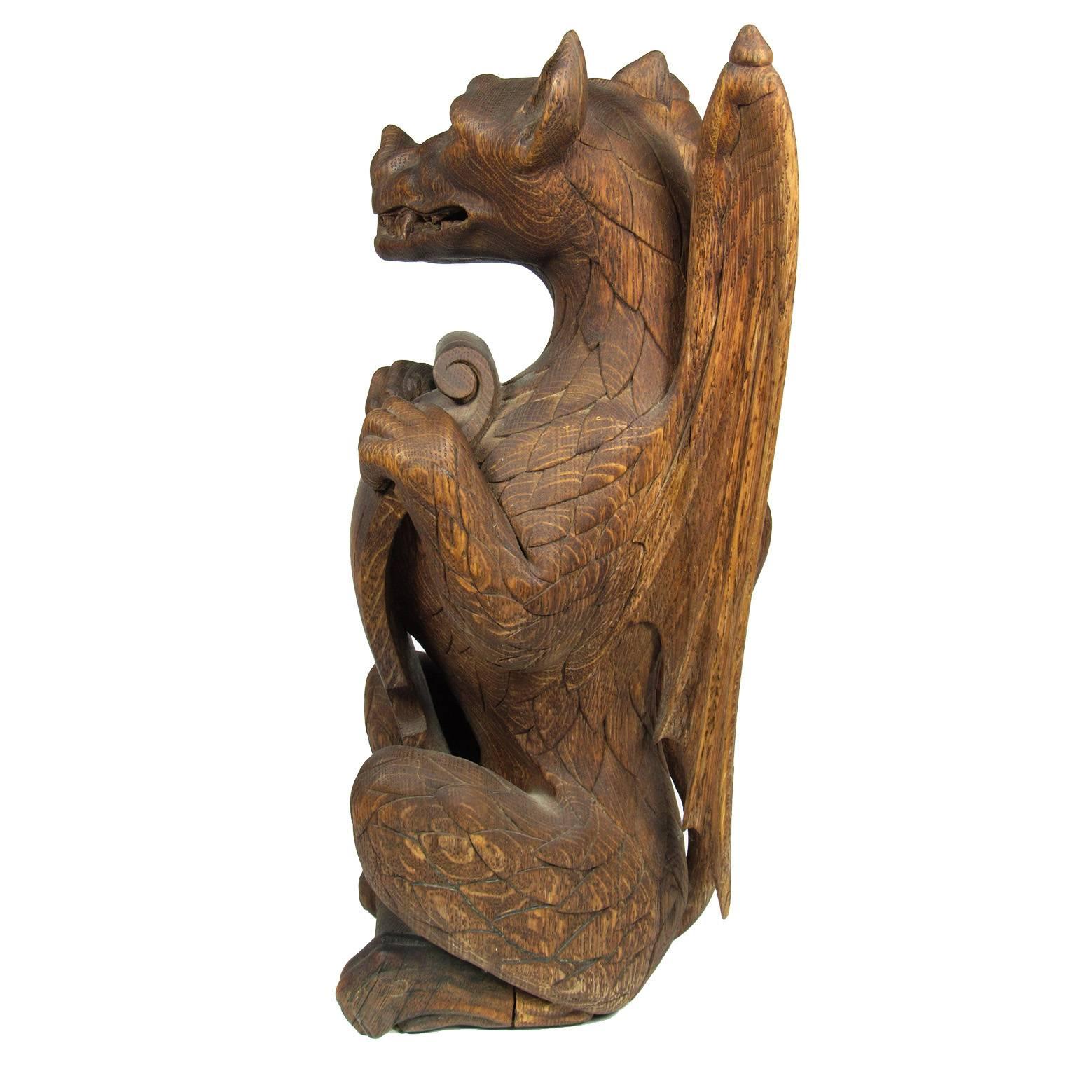 Dramatic 19th century carved wood figure of a dragon holding a shield with great patina;.
Measures: Height 17 inches, width 6 inches, depth 6 inches.