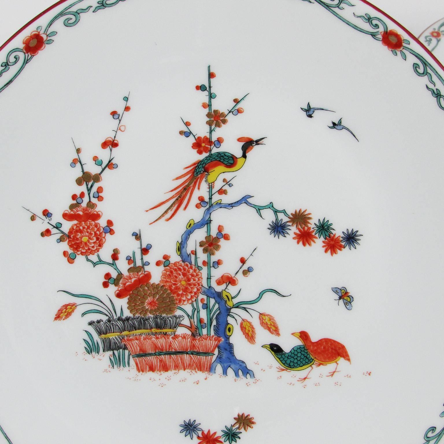 Set of 12 20th century Maison Puiforcat Chankai dinner plates. Multicolored porcelain plate embellished with a basket of chrysanthemums, quails, and birds and a frieze of flowering branches along the rim. Stamped in red 