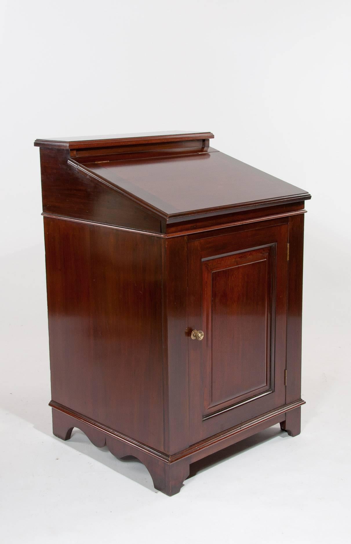 This attractive mahogany Edwardian Davenport / writing desk circa 1900s has been constructed from quality solid mahogany having a raised back above a fall front moulded edge writing slope with a raised and fielded panelled cupboard door standing on