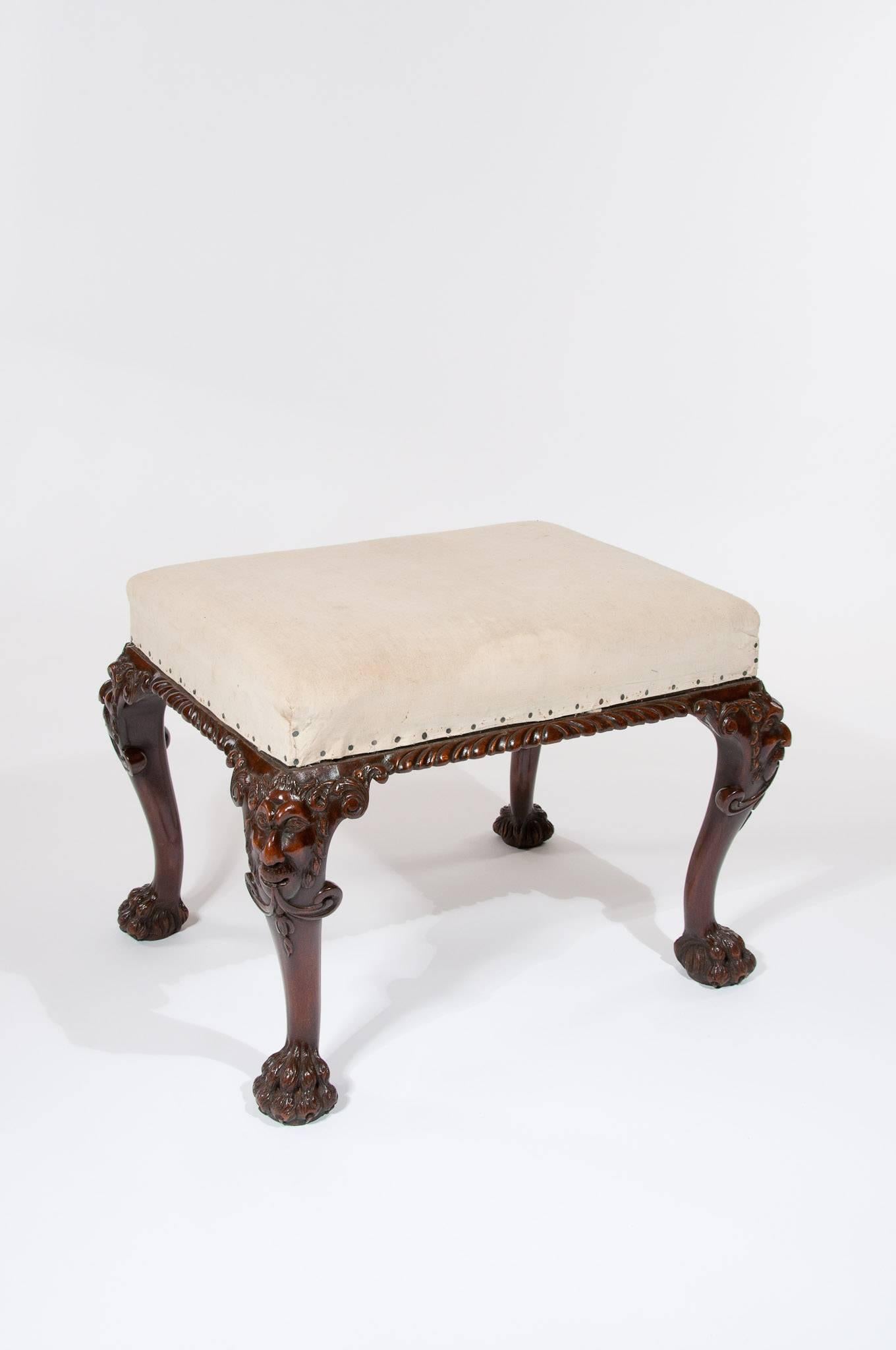 A very good quality antique walnut stool with carved masks to the knee. Of very good form this well carved stool stands on cabriole legs having decoratively carved masks to the knee terminating on hairy paw feet. 

In excellent condition having