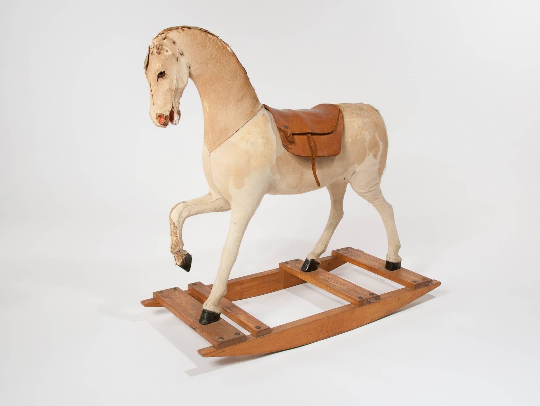 A quality Victorian rocking horse on an oak base. The rocking horse has been constructed from a wooden frame covered in pony skin and filled with wood shavings. With great shape and form in original condition it has an ear missing and various