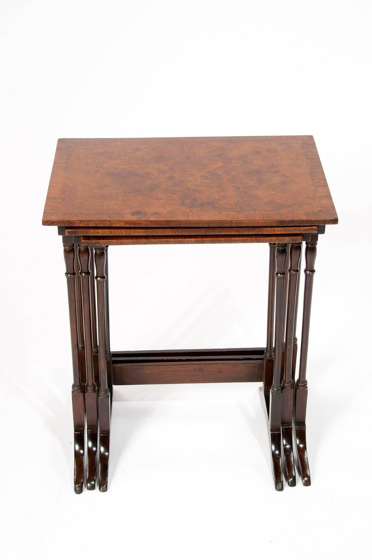 Quality antique nest of burr walnut tables. 
This lovely quality nest of three tables dating to, circa 1910-1920 each having good burr walnut bookmatch veneer and crossbanded edge rectangular tops above four finely ring turned supports on shaped