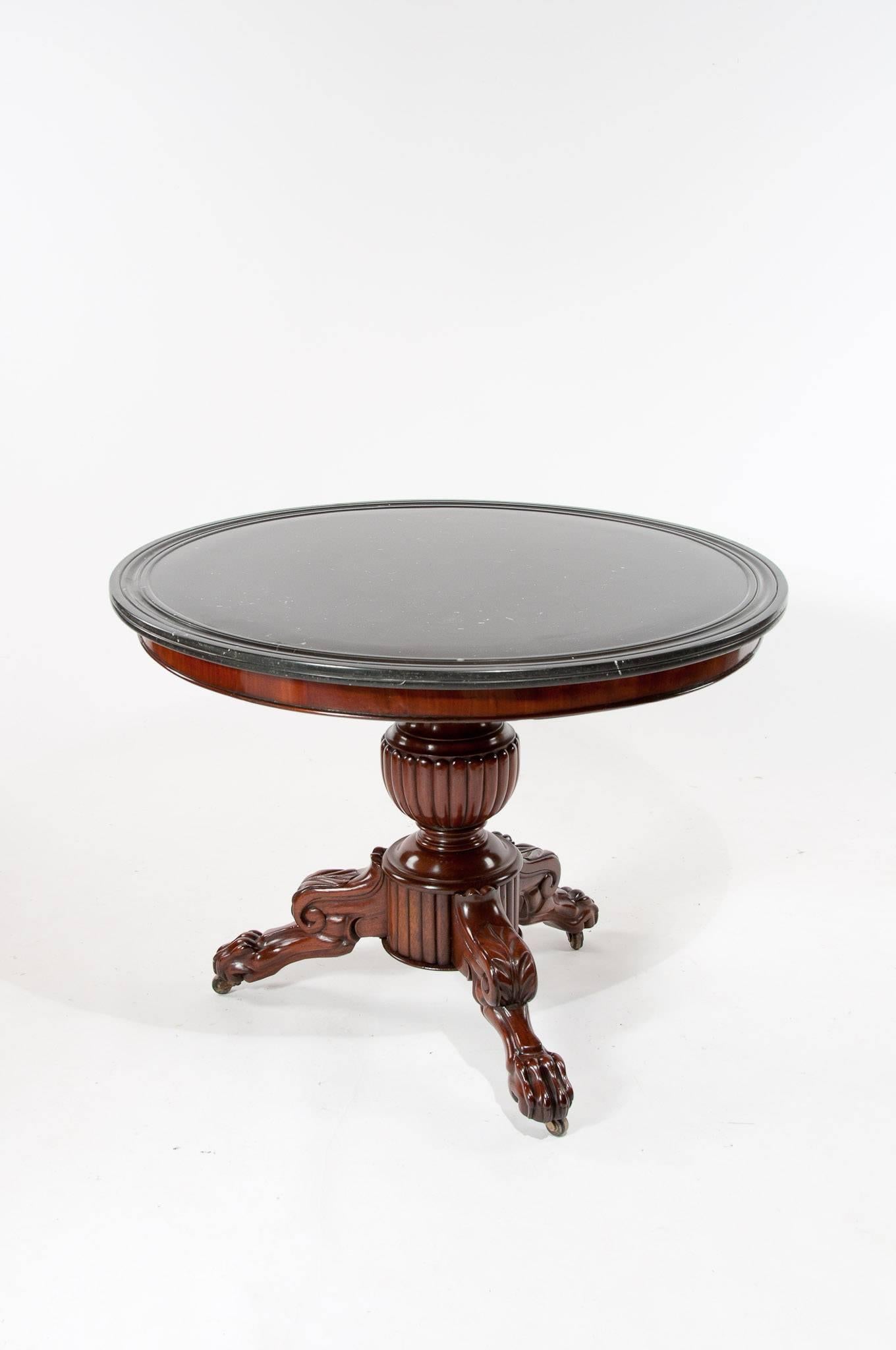 A good quality early 19th century, circa 1830 French marble topped gueridon center table. 

Having its original dished black Belgium marble-top over a circular mahogany veneered frieze with beaded edge supported by a turned and a gadrooned central