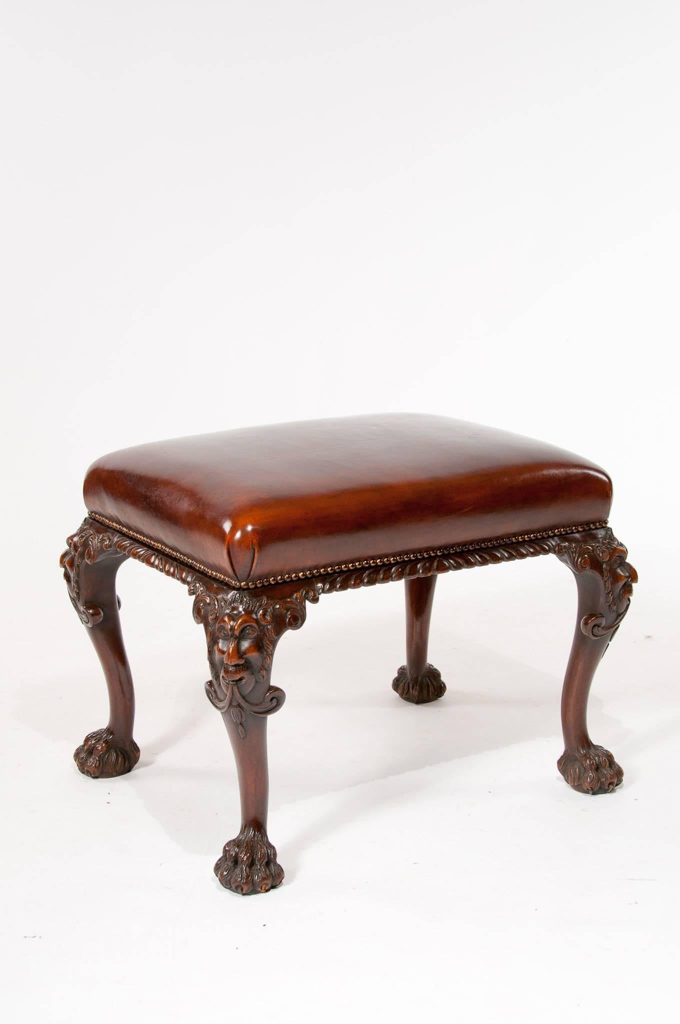 A very good quality antique walnut leather upholstered stool with carved masks to the knee. 

Of very good form this well carved stool stands on cabriole legs having decoratively carved masks to the knee terminating on hairy paw feet. 

The top