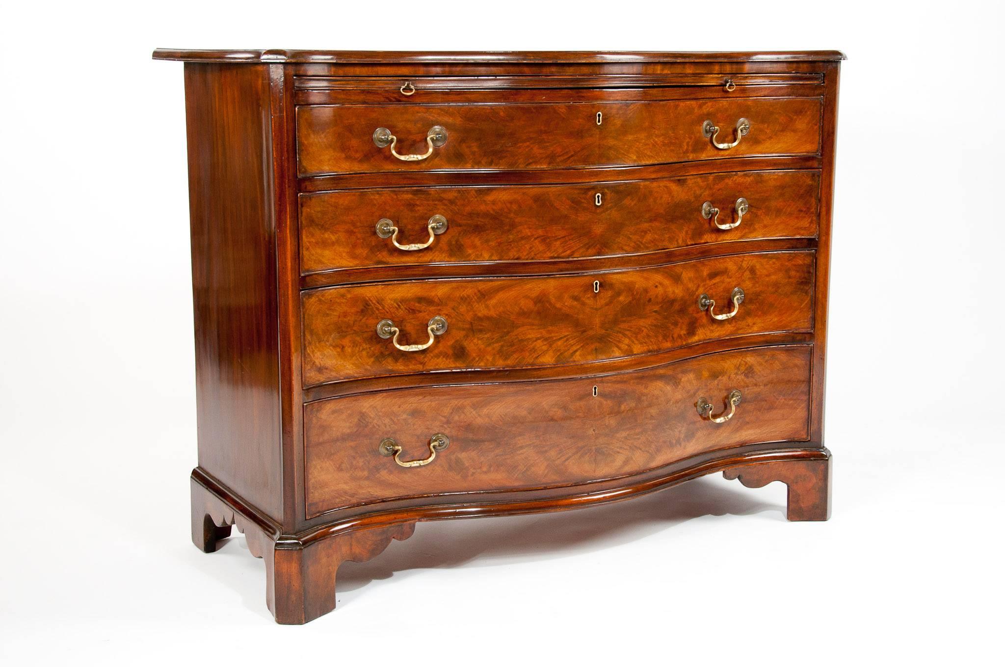 A wonderful flame mahogany serpentine chest of drawers with brushing slide standing on bracket feet.
This fine quality 19th century chest of drawers has been constructed with beautiful slender serpentine and the finest flame mahogany veneers which