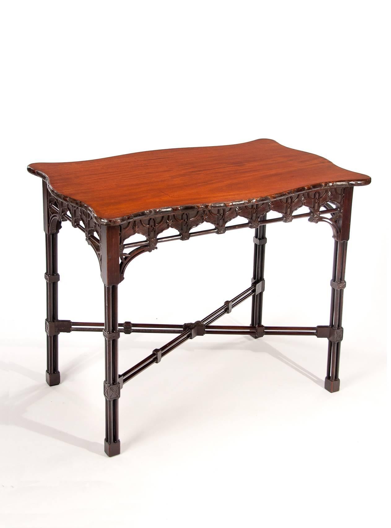Good quality mahogany Chinese Chippendale style centre / silver table, circa 1900.
The shaped top having serpentine outlines with rosette and ribbon twist mouldings, above a blind fretwork frieze with arcading joined by turned rails having pierced
