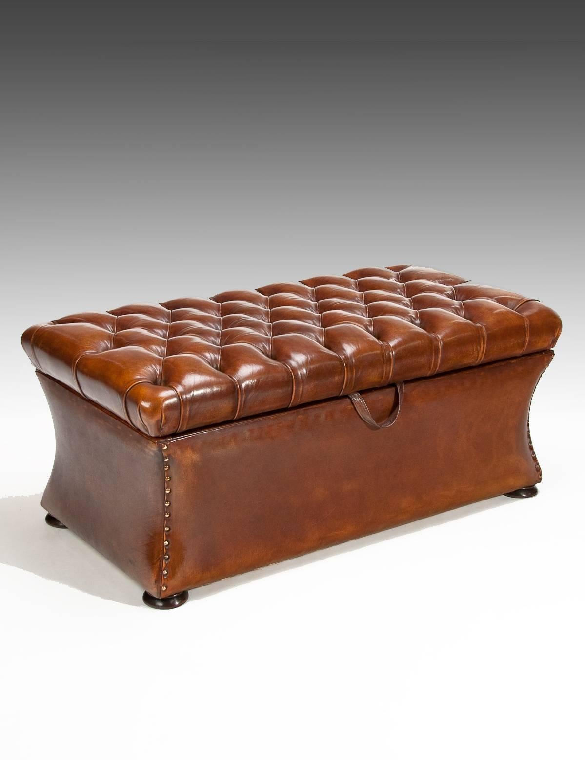 A very good quality late 19th century circa 1880 shaped leather upholstered deep buttoned ottoman. 

The deep leather buttoned top lifts up to reveal a lined storage compartment. Beneath the top the shaped structure being leather lined with brass