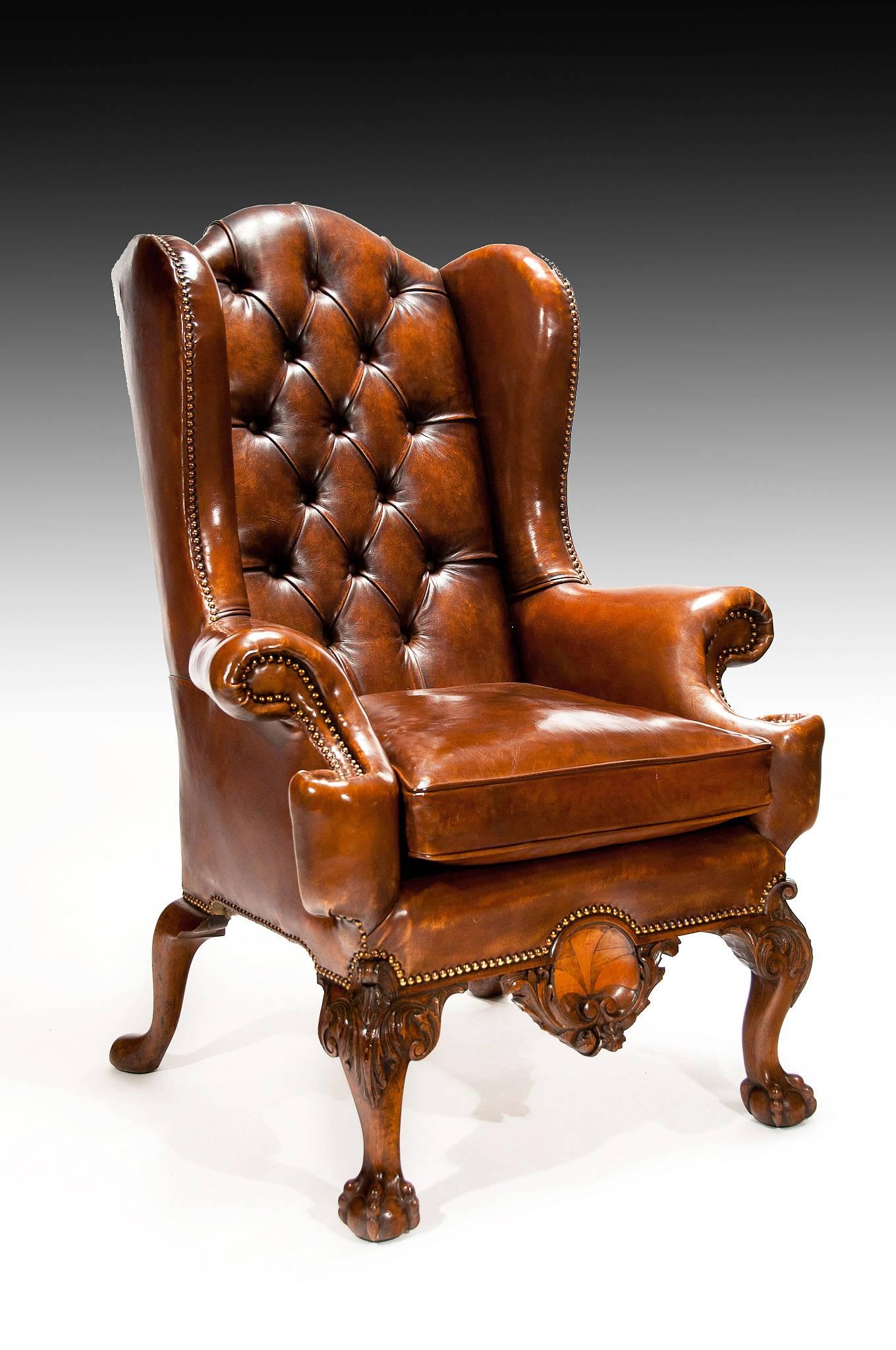 An exceptional 19th Century walnut leather upholstered wing back armchair of excellent shape and proportions.

The deep buttoned leather upholstered back having a serpentine shaped top flanked by out swept winged sides which concave inwards to
