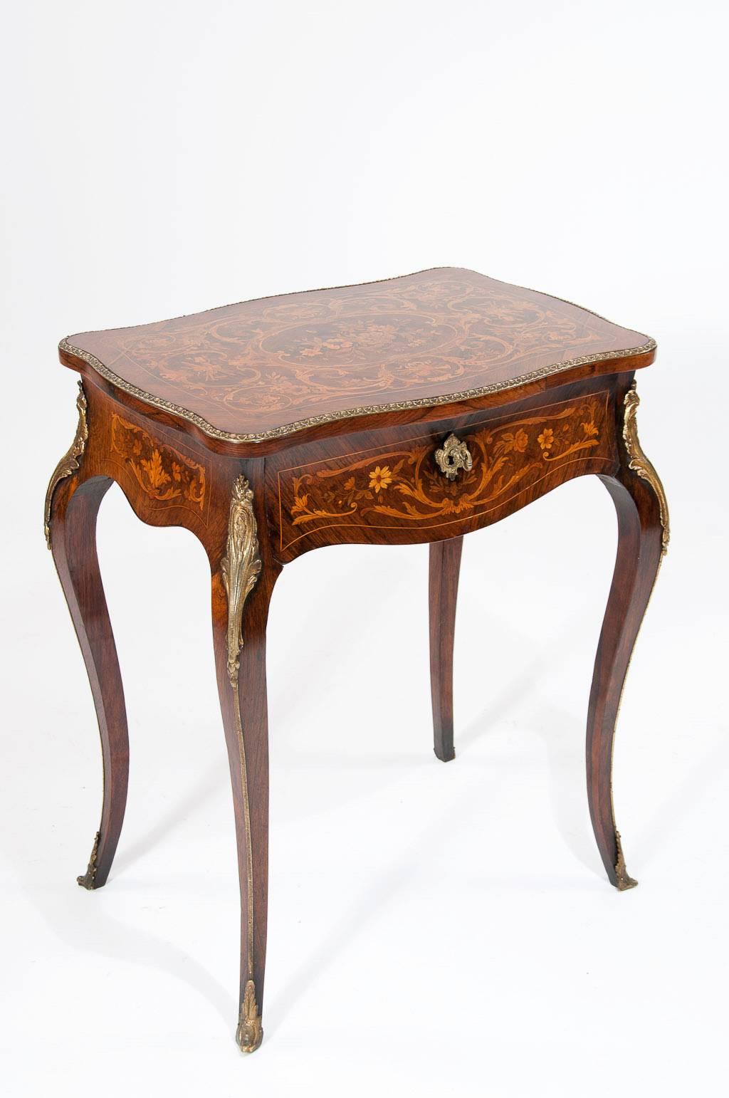 A exceptional quality marquetry inlaid French Louis XV style rosewood gilt metal mounted dressing table or side table with hinged top and pull-out drawer retaining a good color and patina. This lovely French side table / dressing table is of the