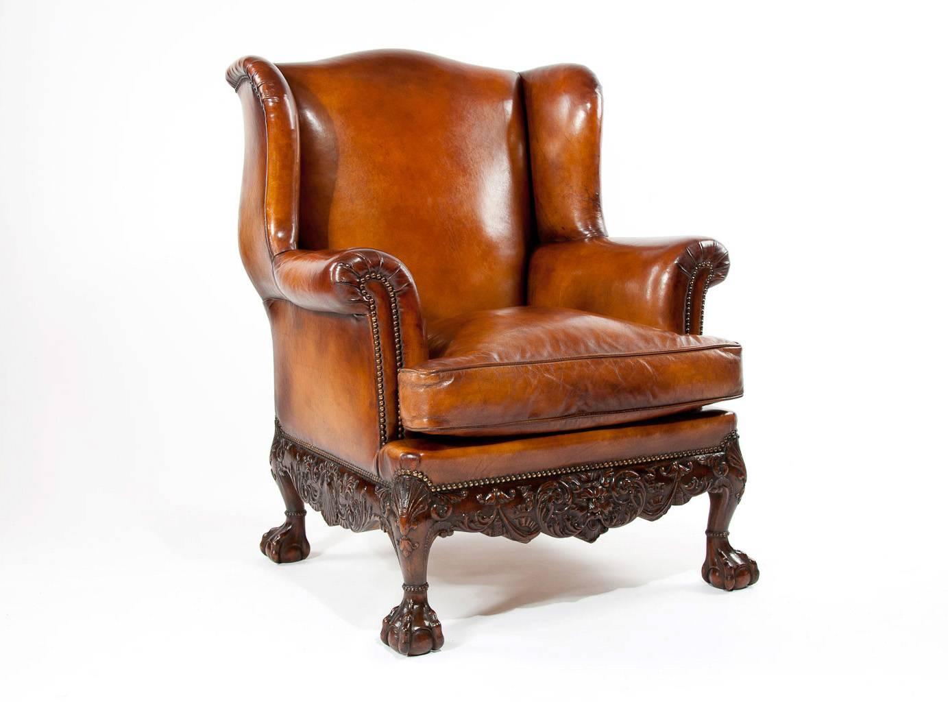 A superb quality carved mahogany 19th century leather upholstered wing armchair dating to circa 1880. This impressive wing armchair of decent size and good proportions has a wide feather cushioned seat making it extremely comfortable. The shaped