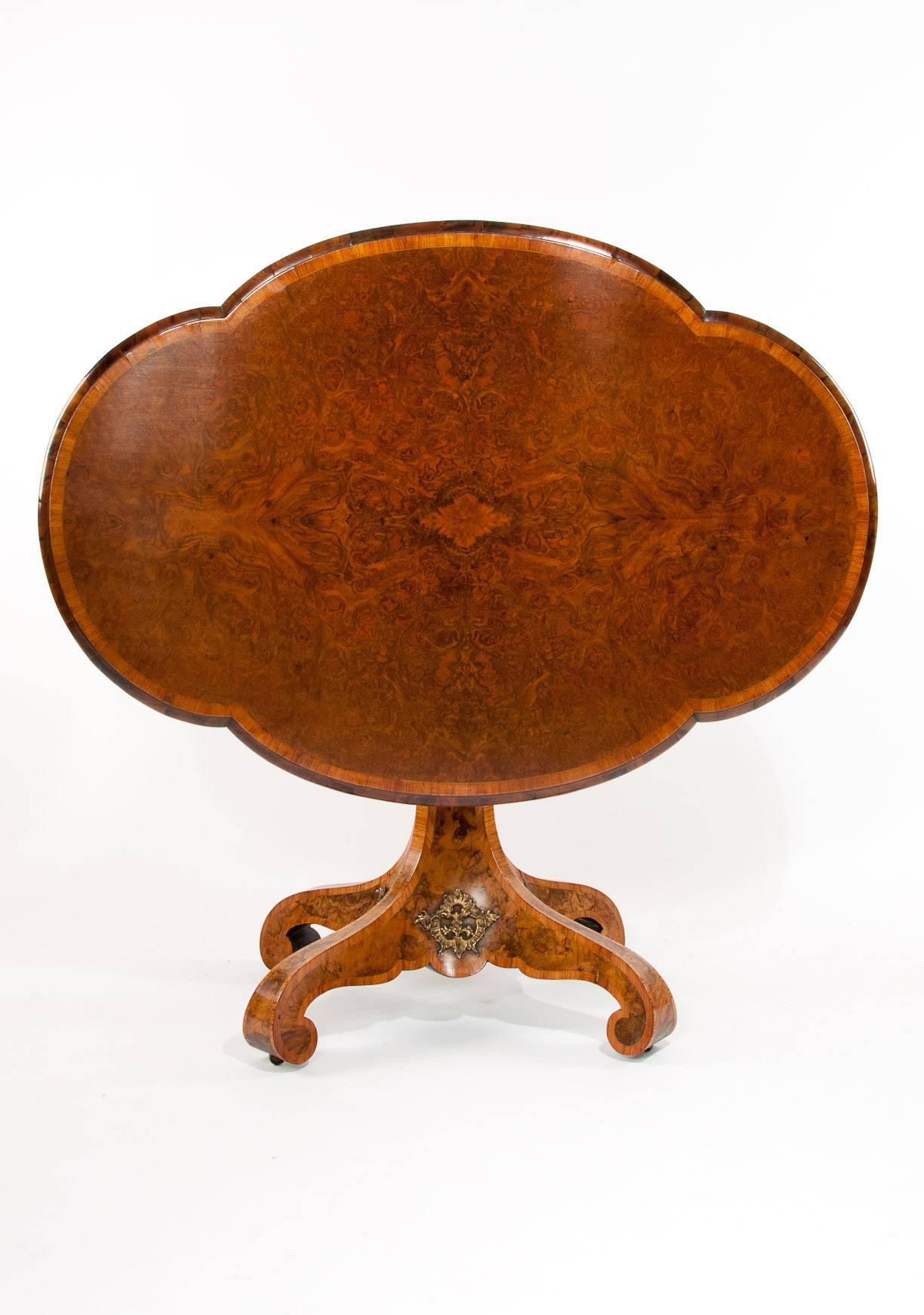 An extremely fine quality and rare shaped 19th Century burr walnut center table dating to circa 1850 in the manner of Edward Holmes Baldock This excellent quality center table has a stunning burr walnut quarter veneered top which when laid in this