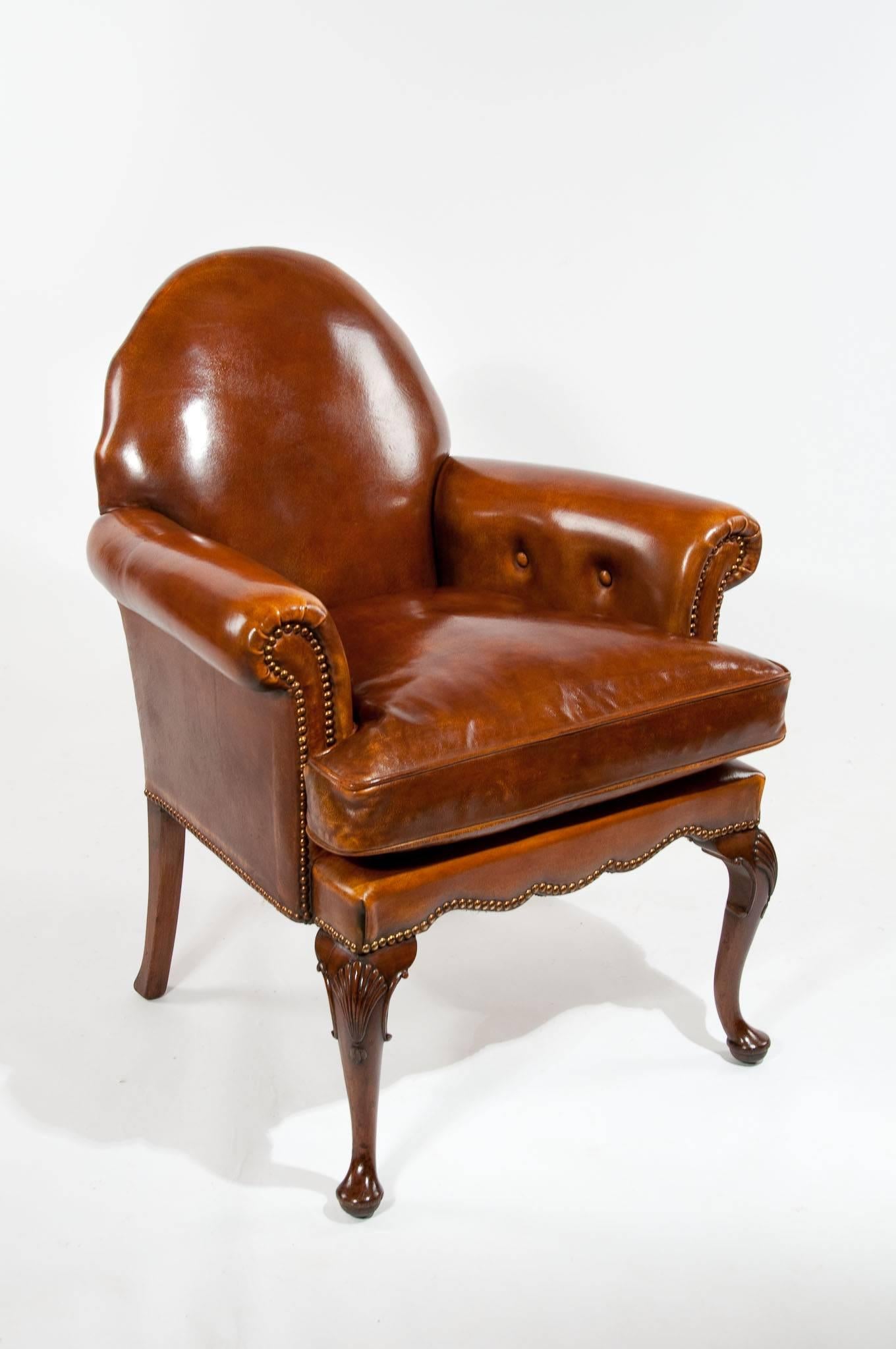 A well proportioned antique walnut cabriole legged leather upholstered armchair. This very attractive leather desk / armchair has a wonderful shaped back with scrolling arms and feather down cushion all upholstered in a first class hand dyed leather