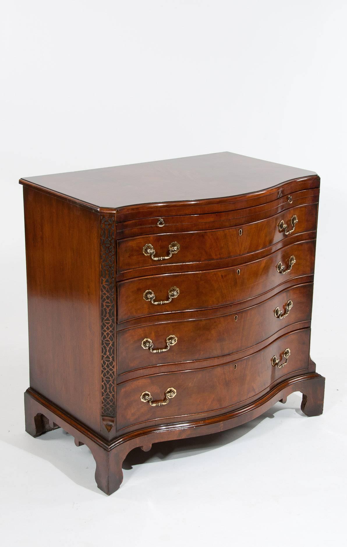 A fabulous quality antique mahogany serpentine chest of drawers dating to the 1900s. This superior quality and well-proportioned mahogany serpentine chest of drawers has a book matched veneered flame mahogany shaped top and cross banded boarder with