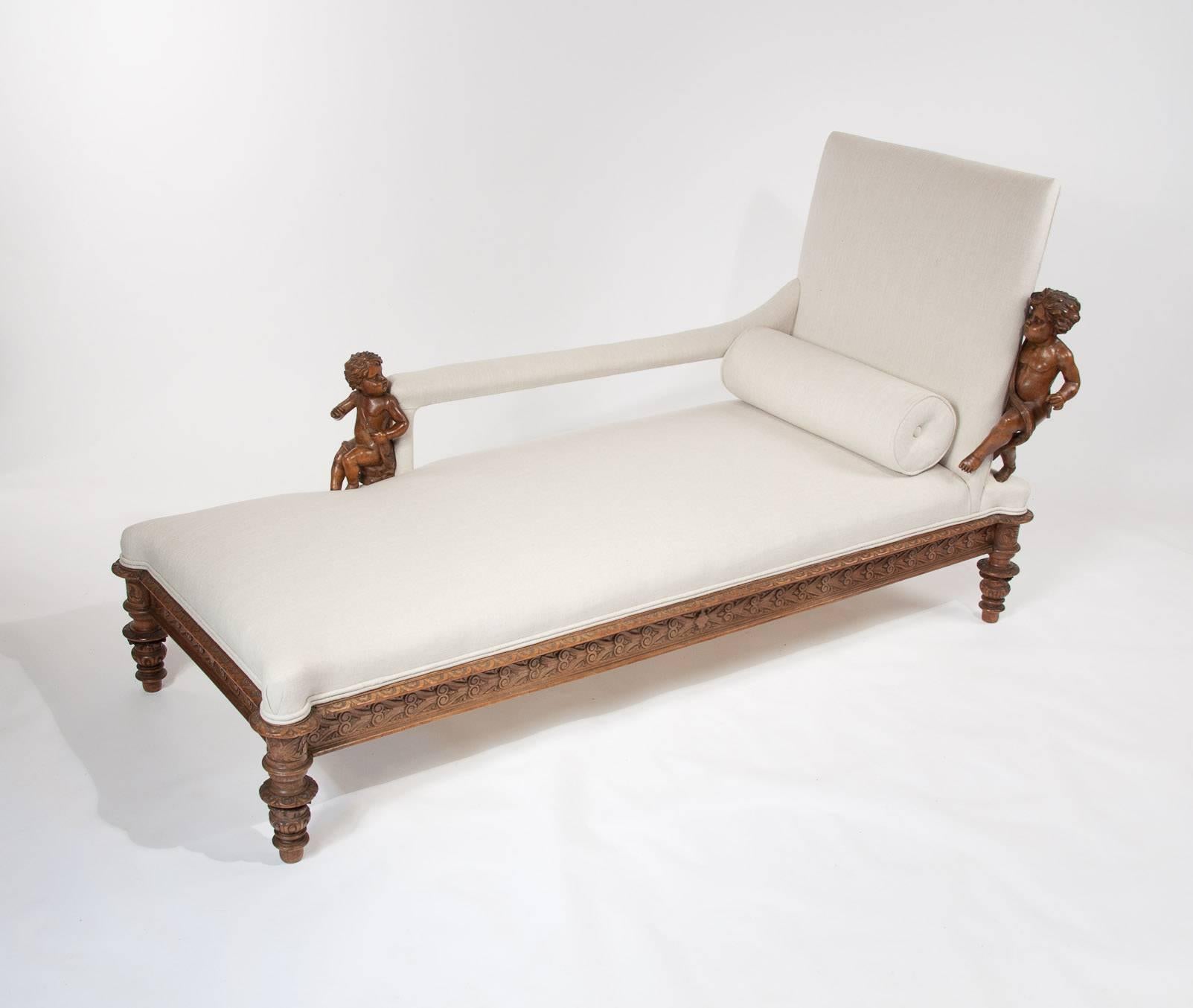 A stunning 19th century carved walnut Italian chaise longue adorned with decorative cherubs. This delightful chaise dating to the mid-19th century originating from Italy is constructed from solid walnut and being newly upholstered is very
