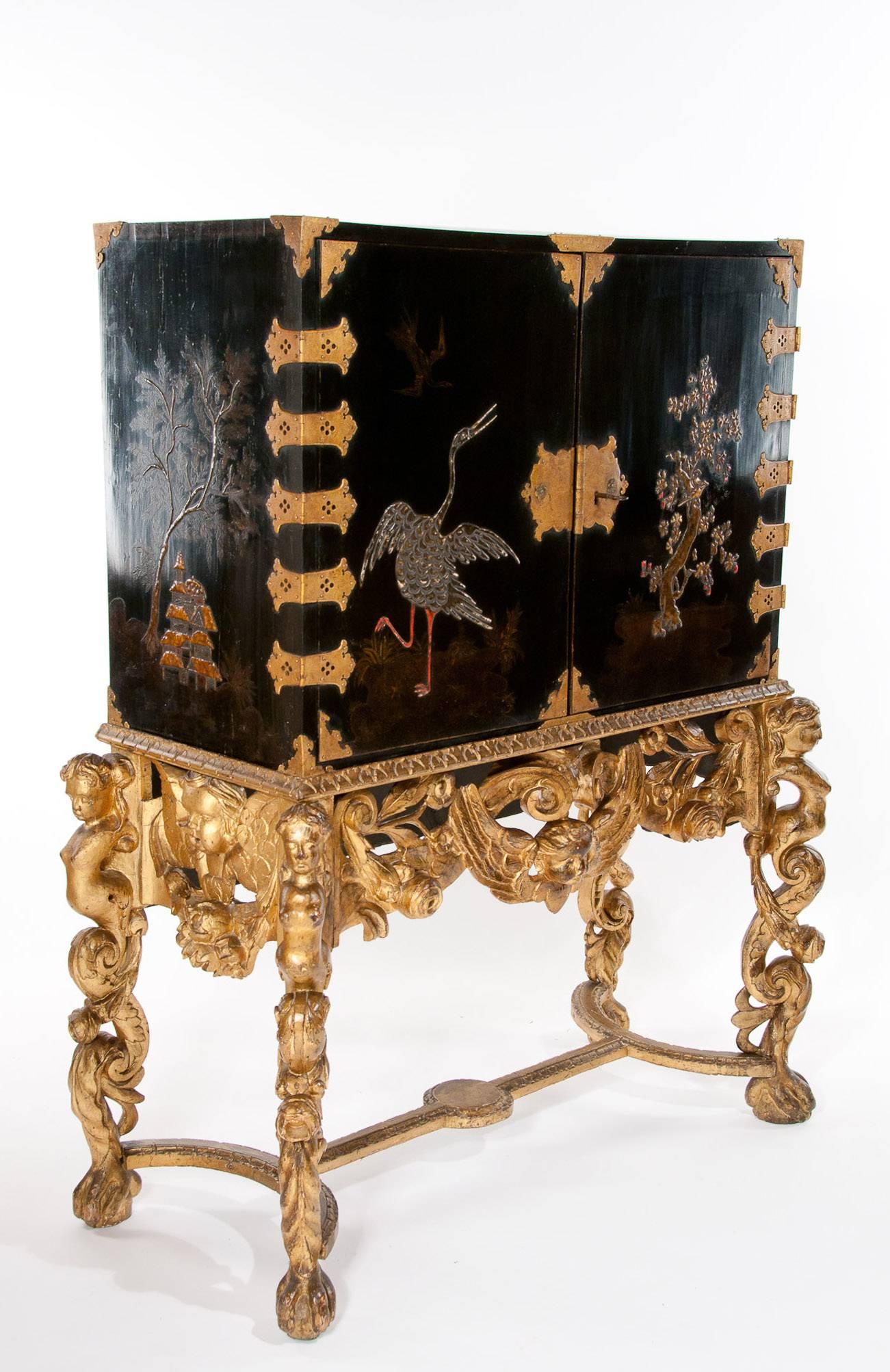 A magnificent 17Th / 18Th Century and later English Japanned Lacquer Cabinet on Gilt carved Stand. This extremely rare cabinet would have been used in the late 17Th Century and early 18Th century as means to show off a wealthy noblemen's exotic