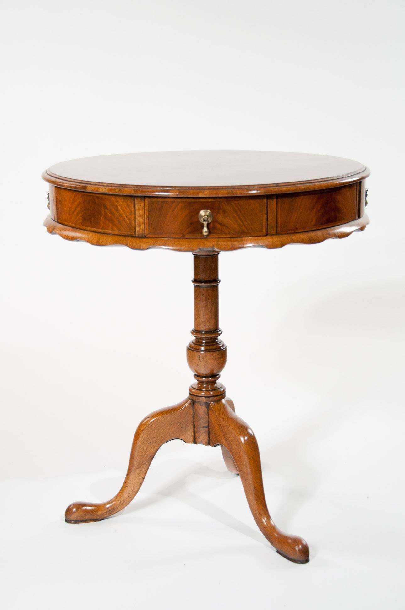 A very good quality antique walnut revolving drum table on a tripod base with four drawers.
Having a circular top which has been quarter veneered in walnut with a crossbanded surround and endgrain moulded edge over a circular frieze contained four