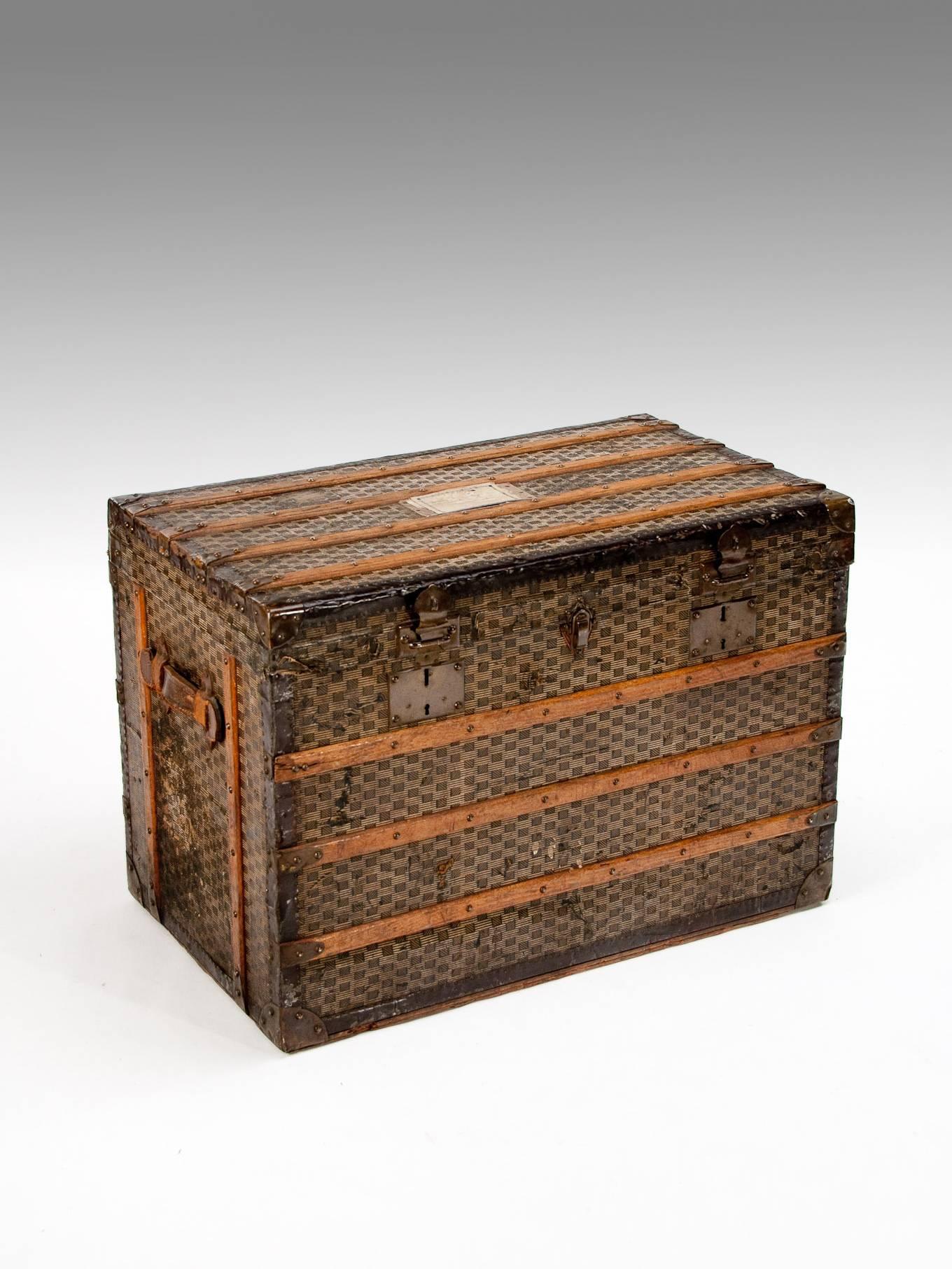 A beautiful and Classic well sized antique French steamer trunk with the locks stamped Paris F.A.M.
In very much the Goyard manner this turn of the century travelling luggage or trunk has a monogrammed cover with a wooden strapping surround being