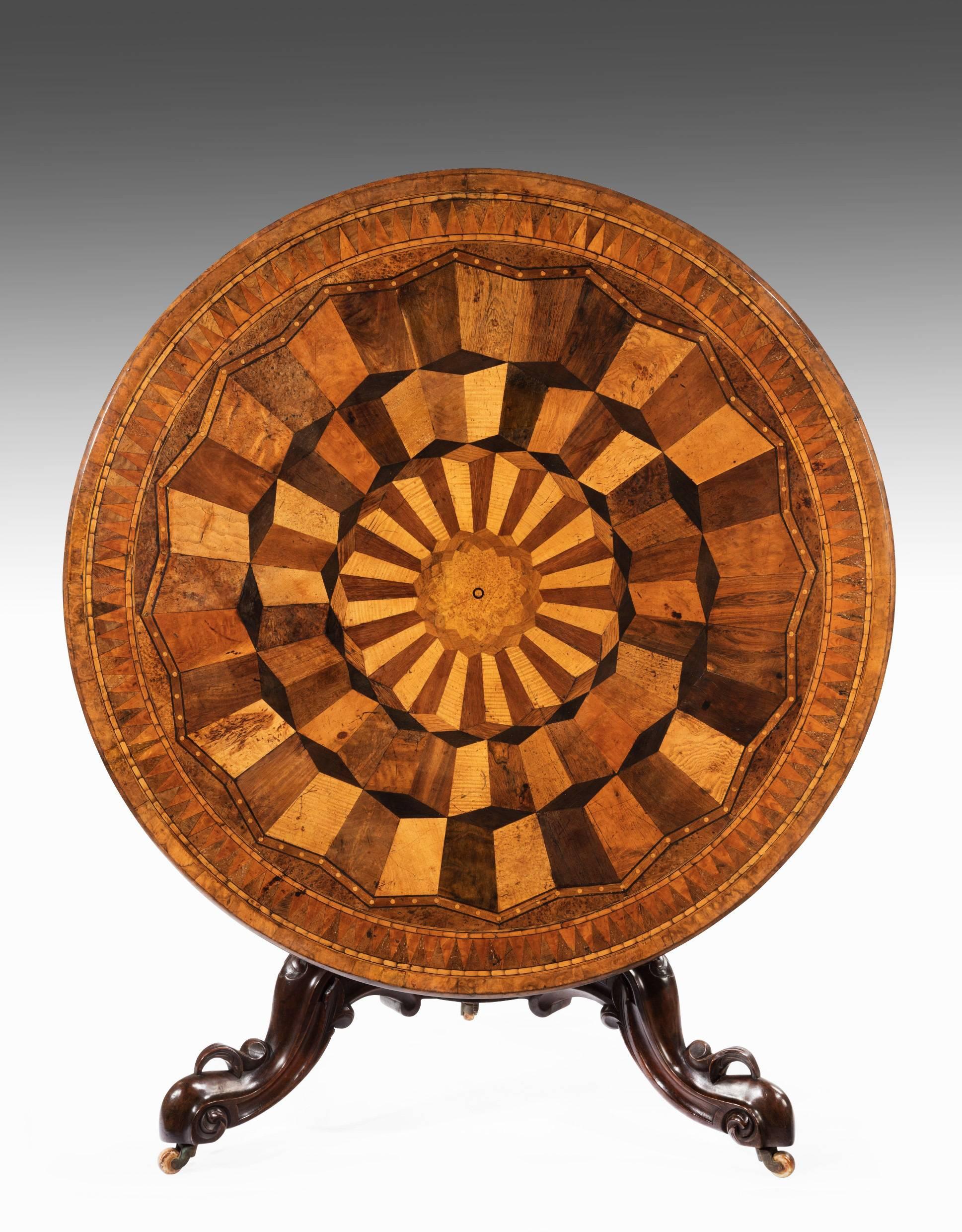 An exceptionally fine and rare mid-19th-century exotic specimen wood table.
This superb quality table of large proportions has a circular top adorned with a multitude of exotic woods laid in parquetry form with a burr walnut crossbanded edge. The