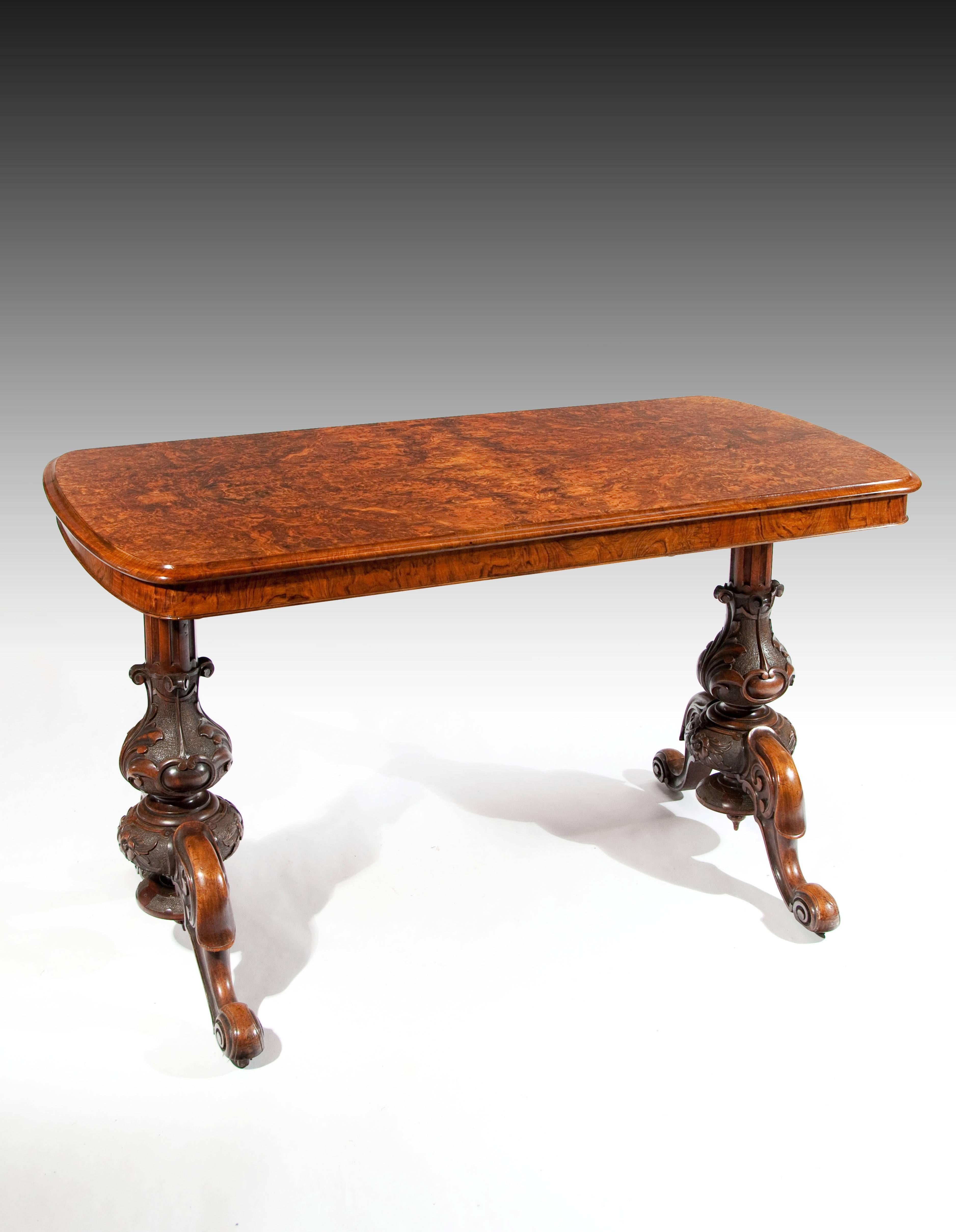 A superb quality Victorian burr walnut end support table. 

Having the finest quality burr walnut quarter veneered top with a thumb moulded edge over a burr walnut frieze. Raised on fabulously carved and fluted end supports with acanthus leaf