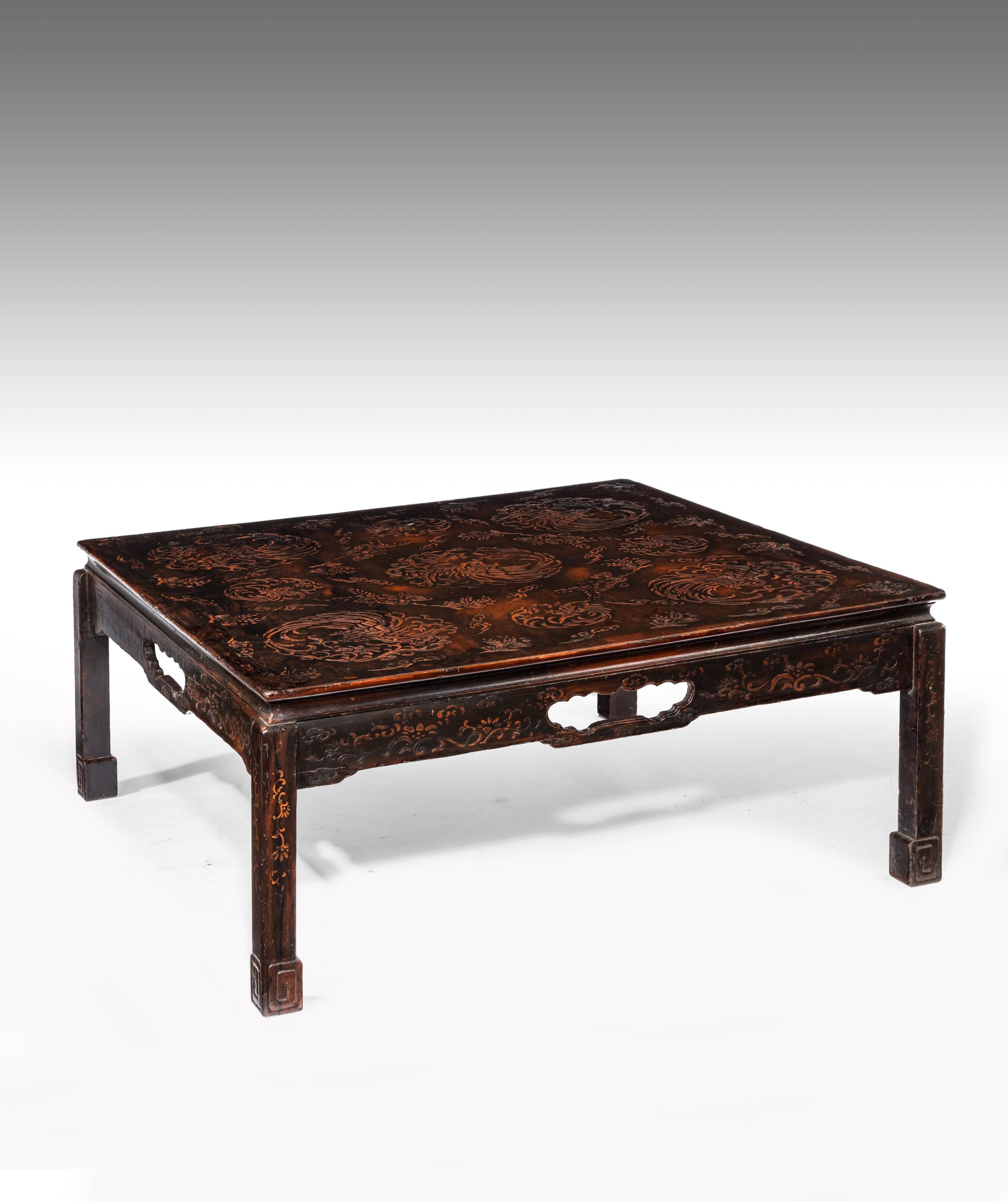 A well-proportioned Chinese raised lacquered Mid-20th century coffee table.
With a square decorative raised lacquered top sitting over a shaped frieze with a central fretted opening supported by four square cut legs with box foot.  

In very good