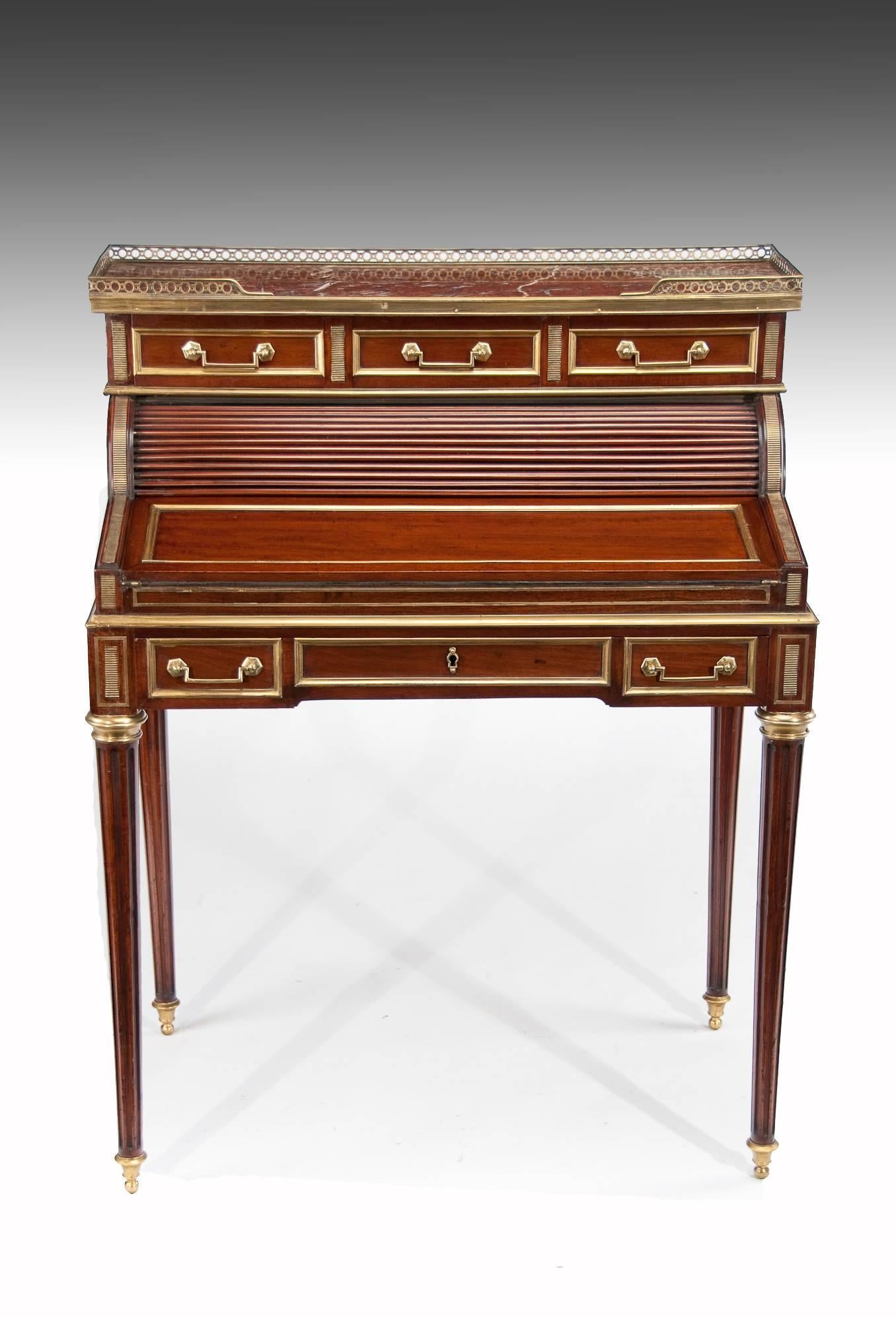 A very good quality Louis XVI style mahogany and brass French tambour ladies writing desk / Bonheur du jour late 19th century.
This attractive desk has a rouge marble with a surrounding brass fretted gallery below which are three drawers with brass
