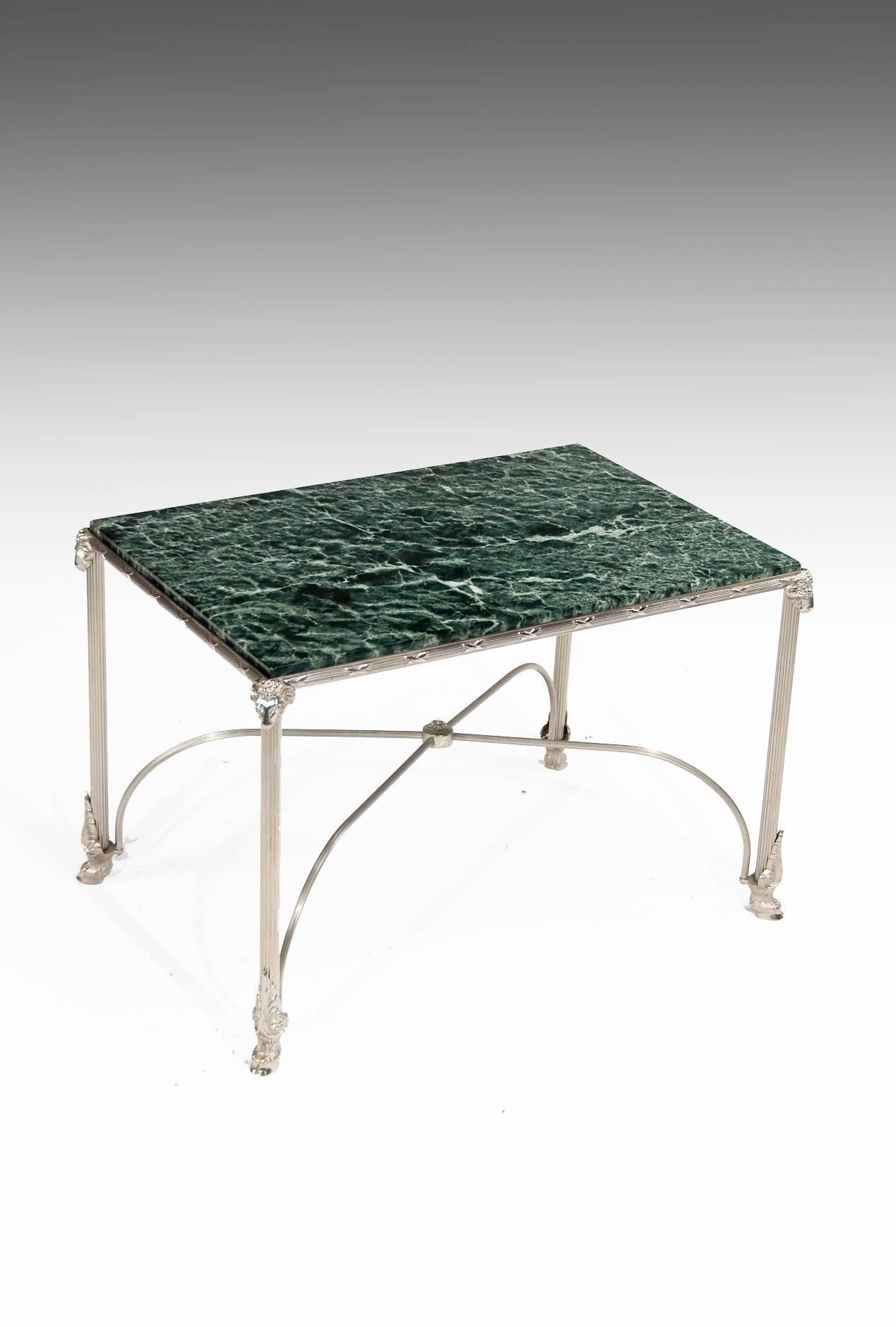 A very fine quality 1920-1950 Nickel plated marble topped occasional table. Having a very good quality veined marble top supported by four reeded legs with ram's head capitals united by a shaped X frame stretcher raised on hoof feet. In superb